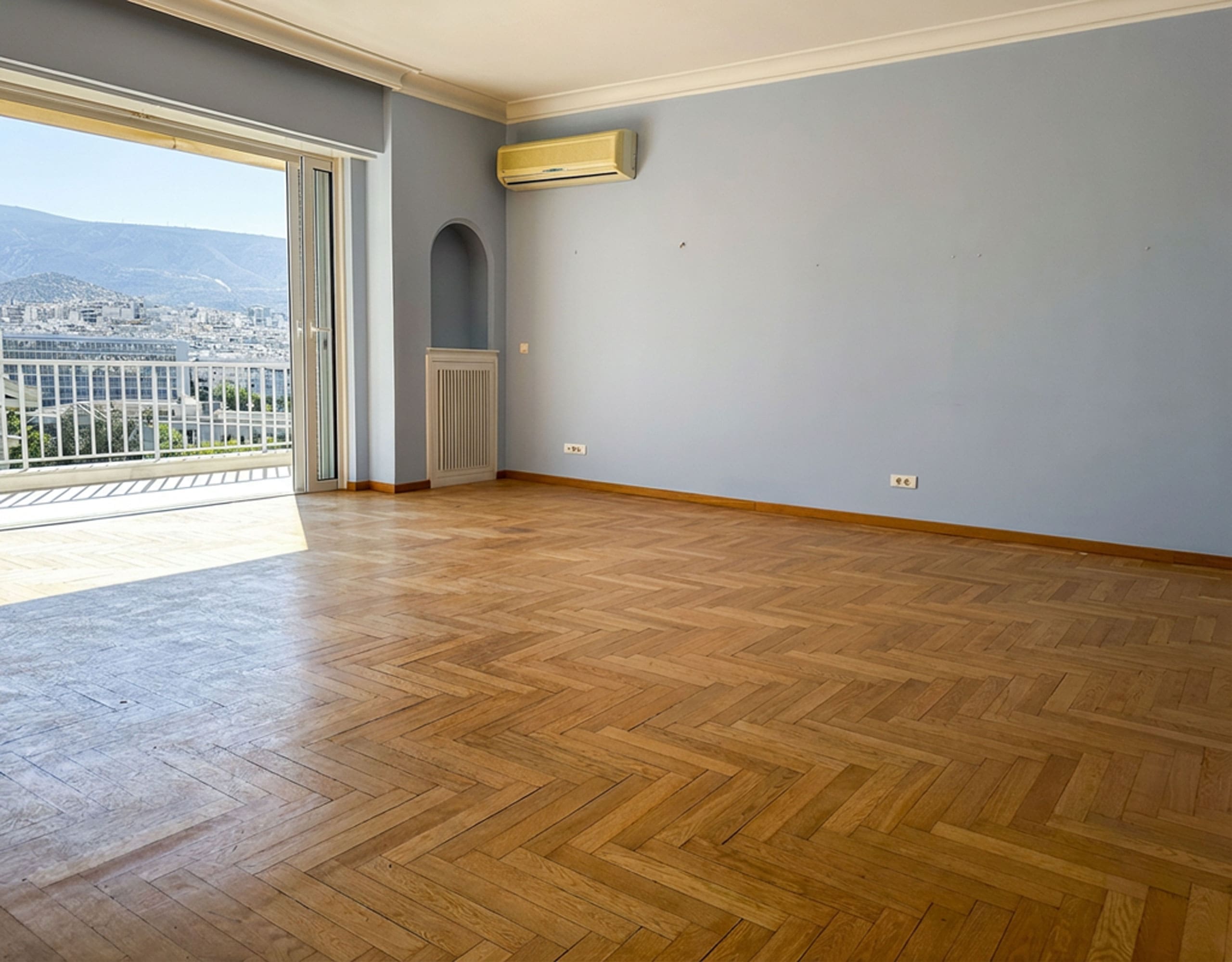 Spacious empty living room with wood flooring and large balcony doors, Anaktora, Kolonaki, Athens, Greece