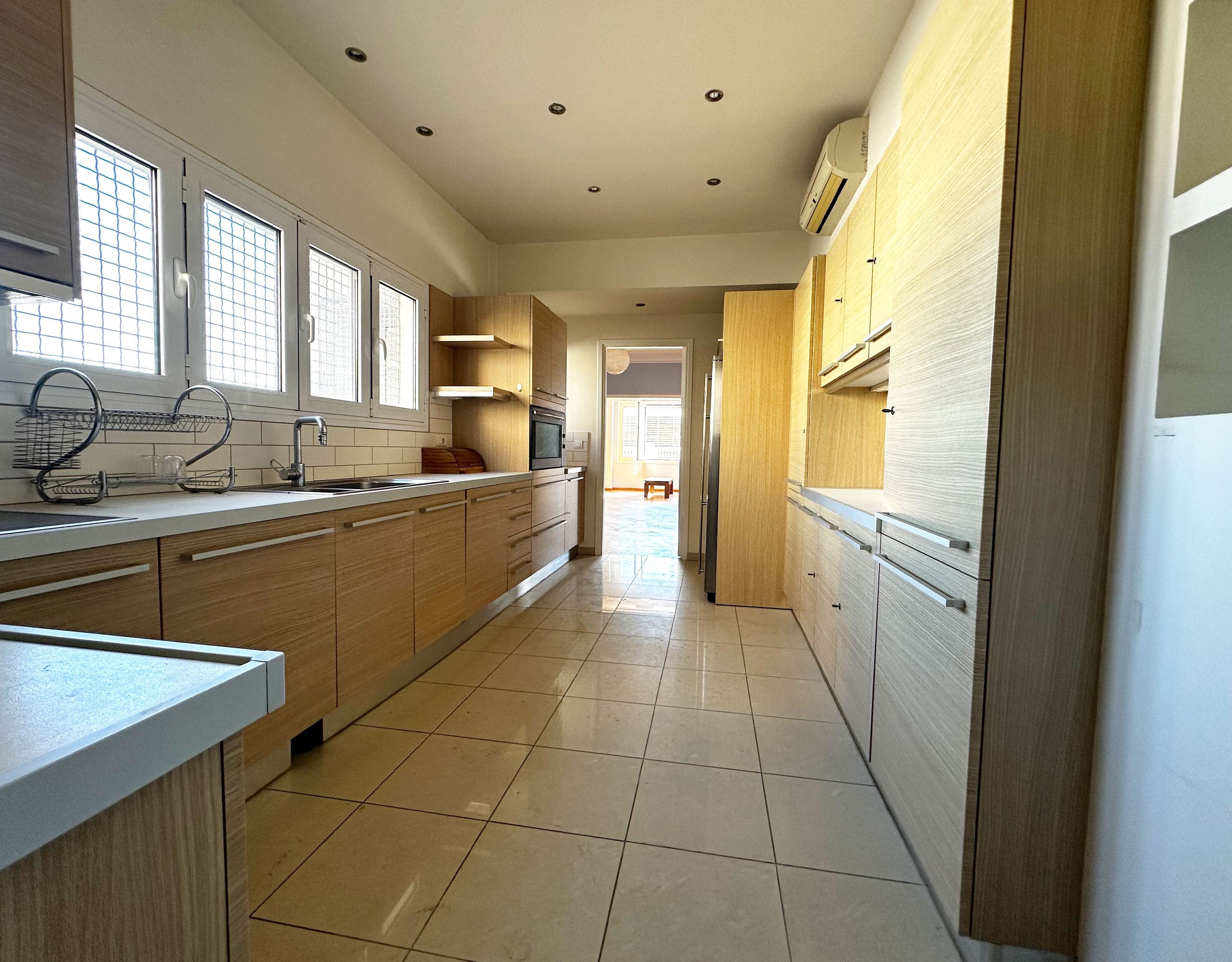 Kitchen counter and sink area with wood cabinets and tiled floor, Anaktora, Kolonaki, Athens, Greece