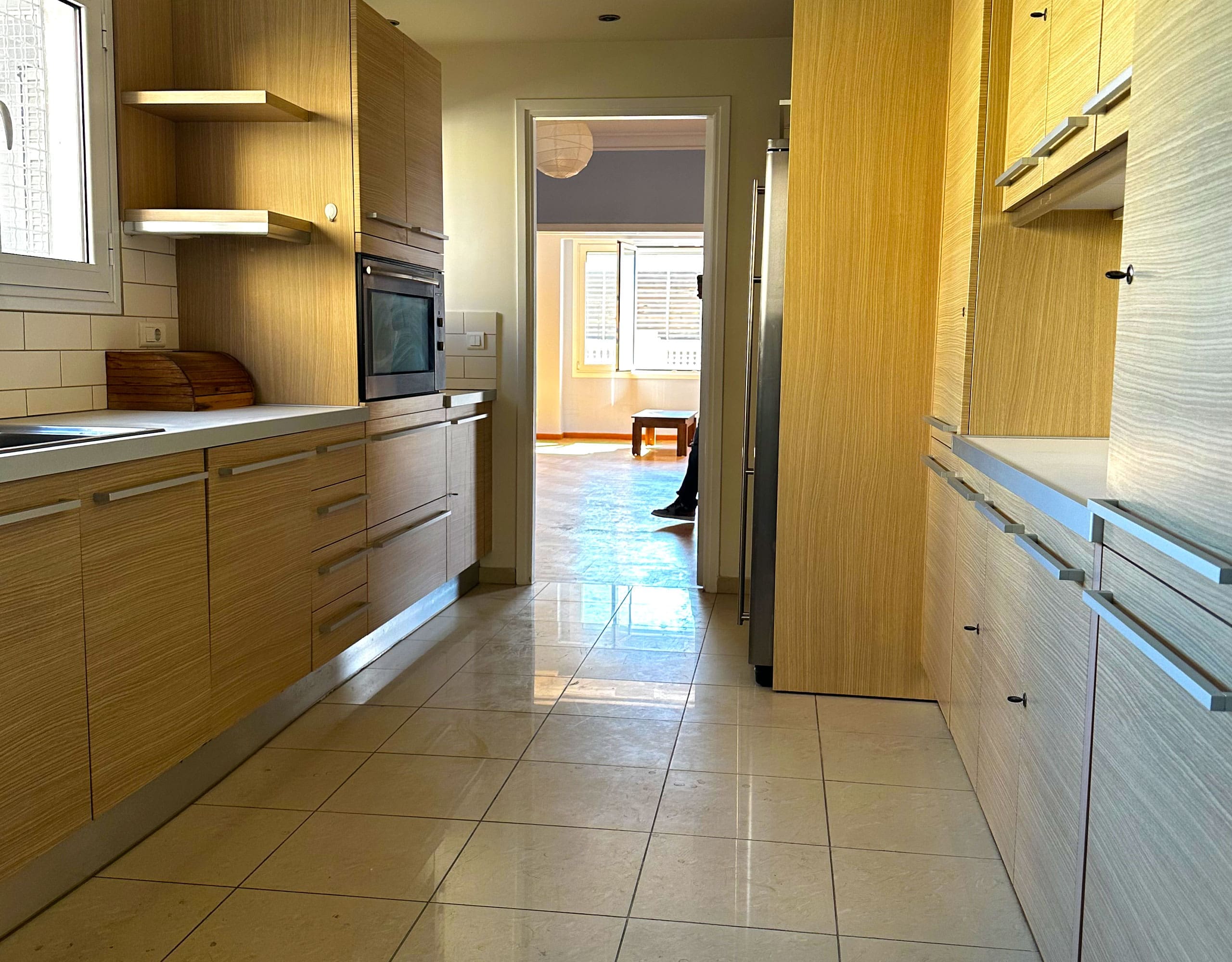 Galley kitchen view with wood cabinetry and corridor layout, Anaktora, Kolonaki, Athens, Greece