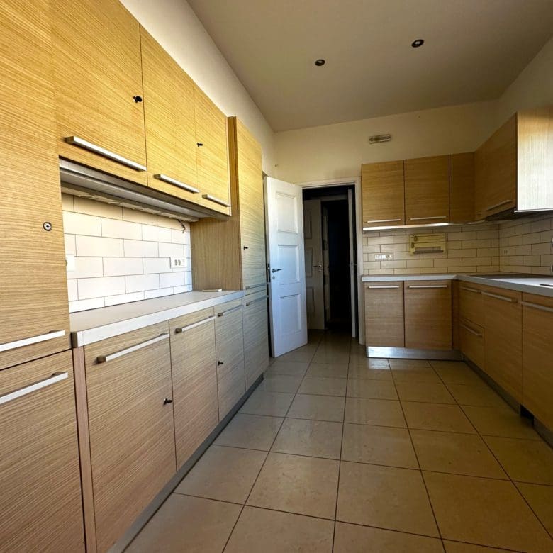 Long kitchen with wood cabinetry, tiled floor, and window for natural light, Anaktora, Kolonaki, Athens, Greece