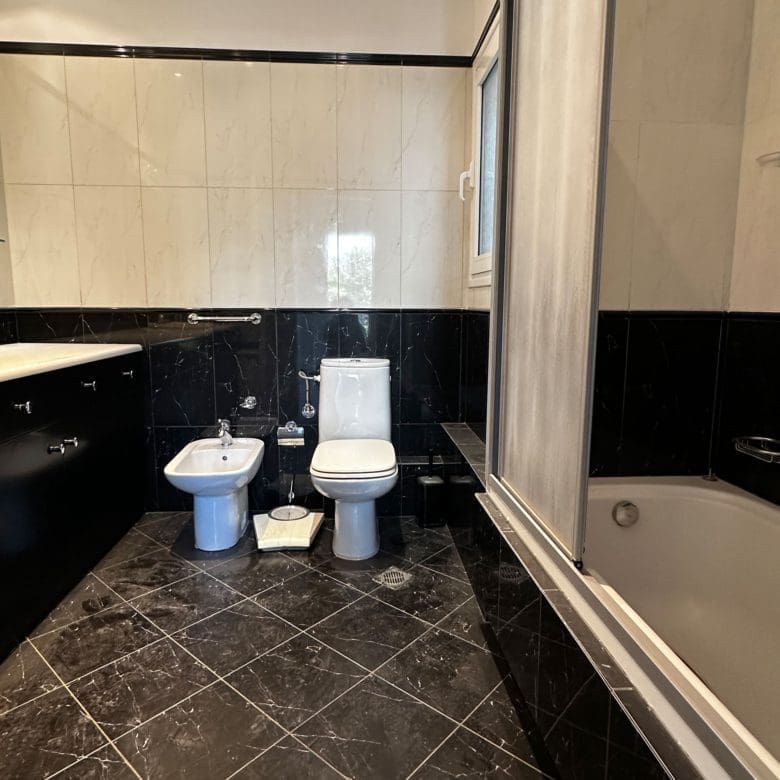 Bathroom bathtub area with black tile floor and white wall tiles, Anaktora, Kolonaki, Athens, Greece