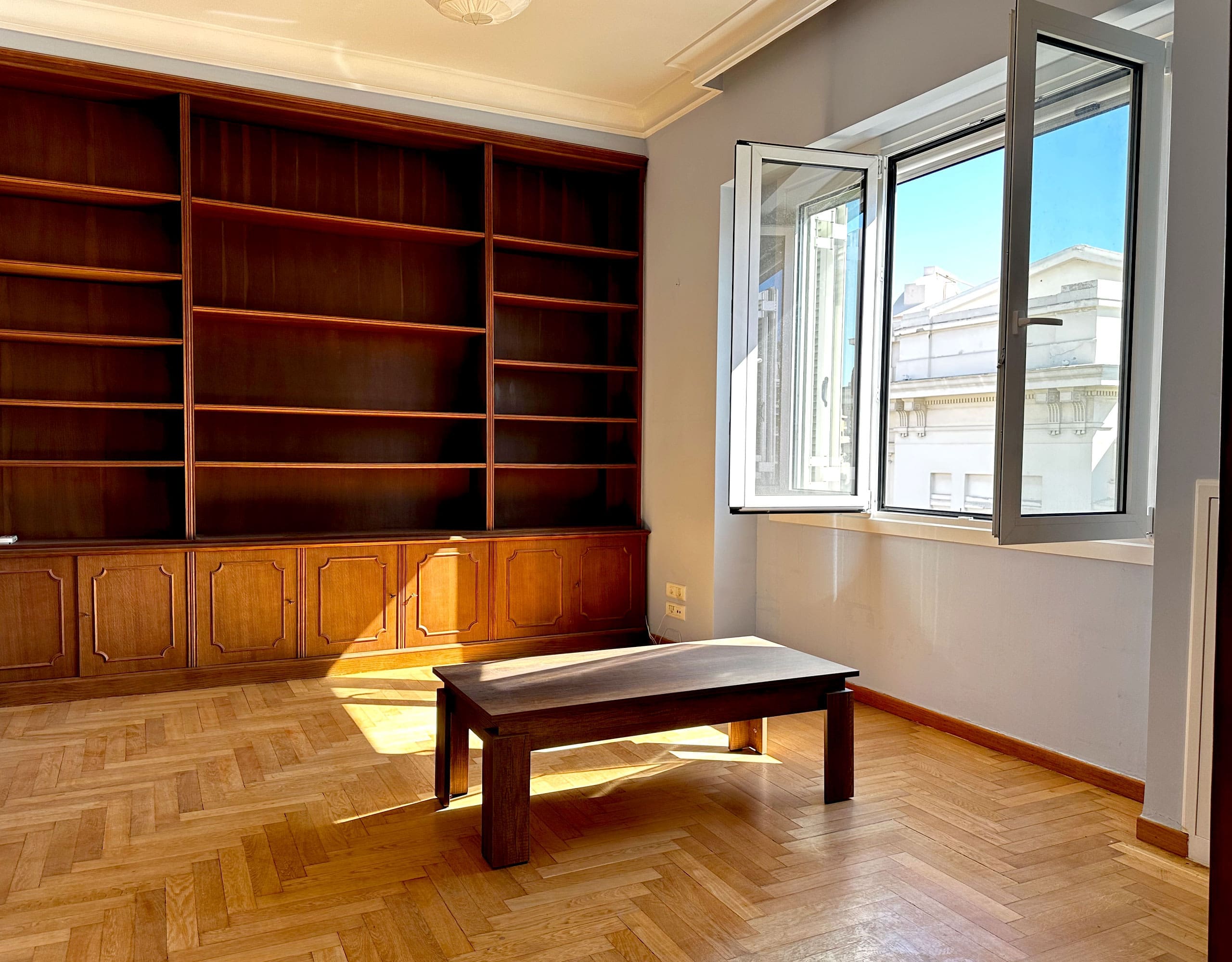 Room with built-in wall shelving, wood flooring, and open window, Anaktora, Kolonaki, Athens, Greece