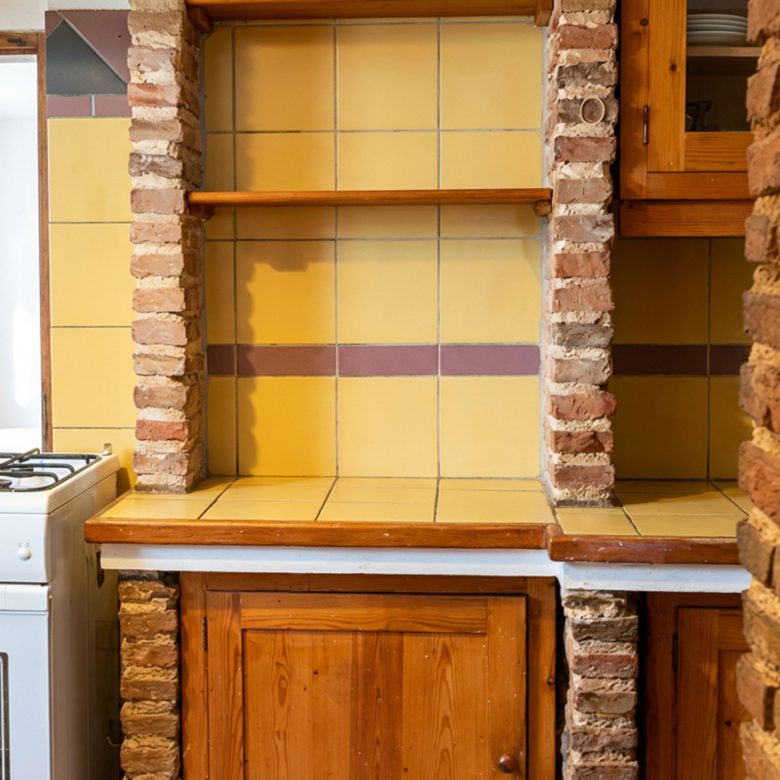 Kitchenette area with tiled backsplash and wooden cabinetry in hotel property in Limi, Evia