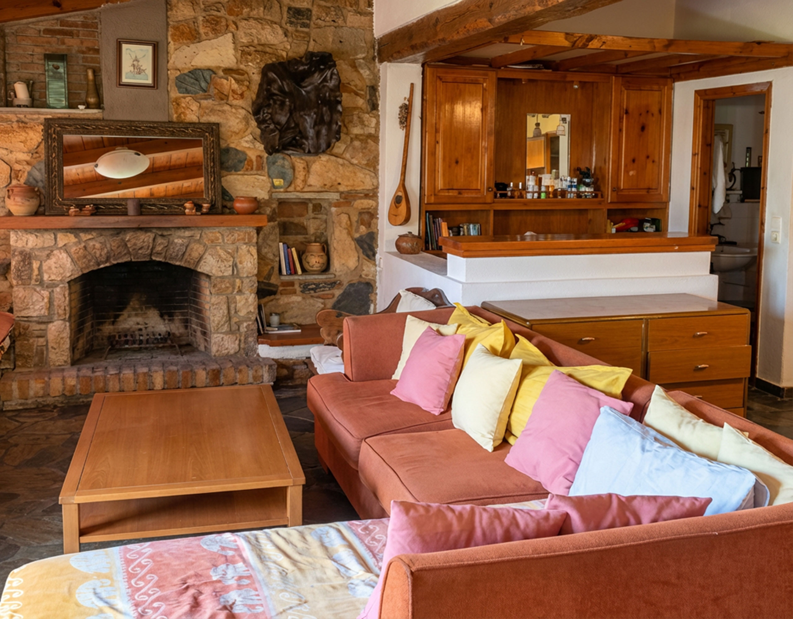Lounge area with stone fireplace and bar counter in hotel property in Limi, Evia