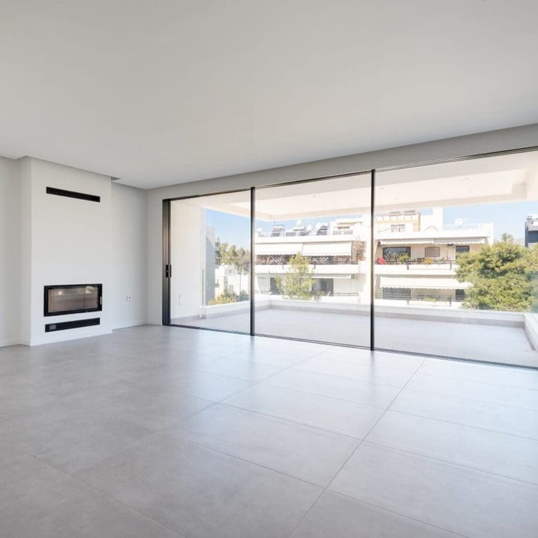Bright open-plan living area with large sliding doors and built-in fireplace niche, Athens Riviera, Greece