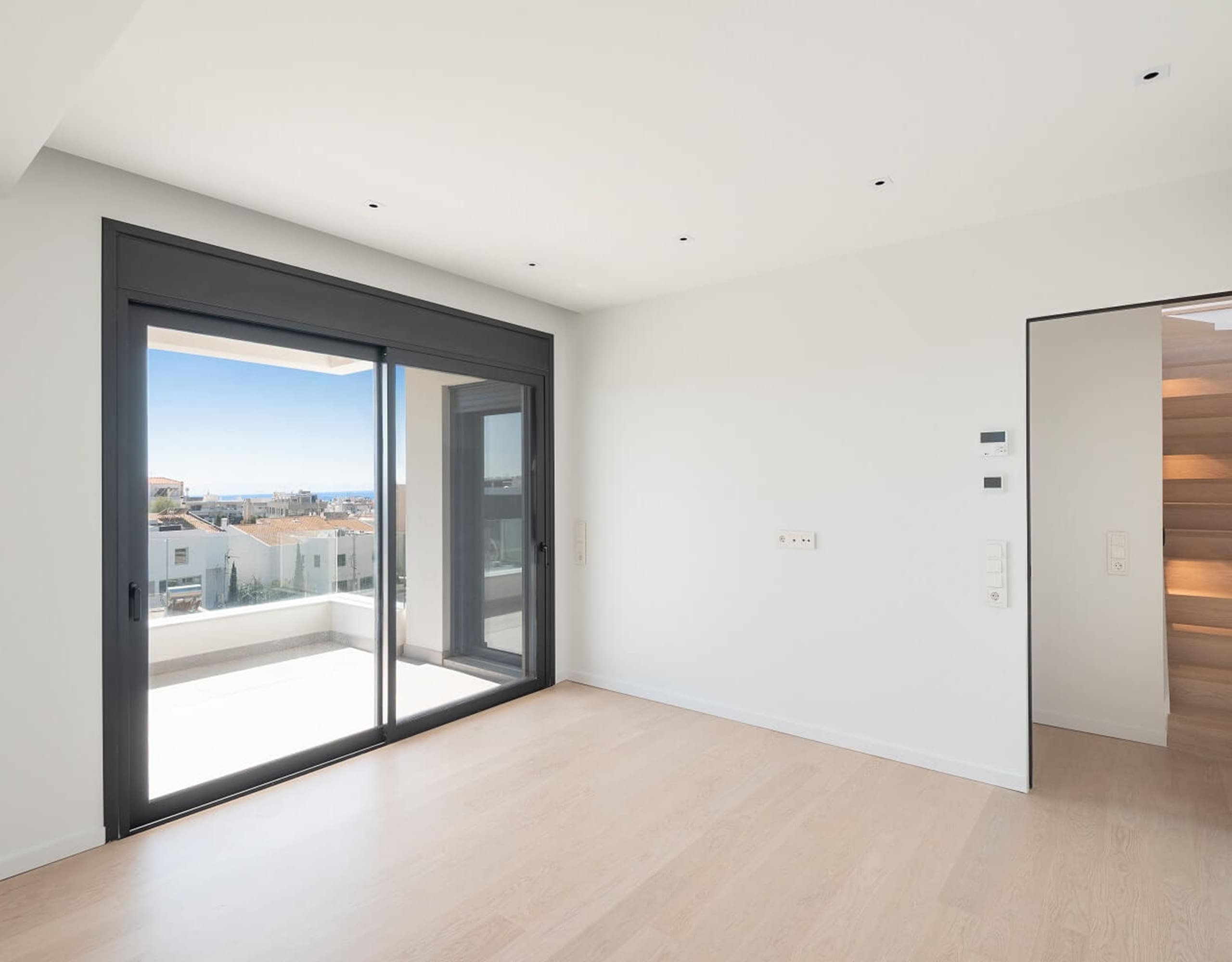 Bright modern room with large sliding doors opening to a balcony, Athens Riviera, Greece