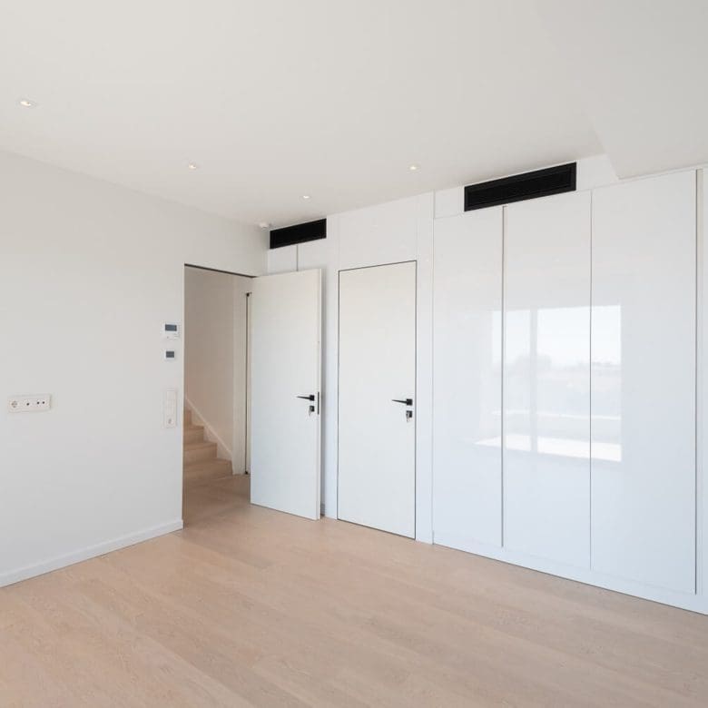 Minimal interior with glossy built-in wardrobes and clean white walls, Athens Riviera, Greece