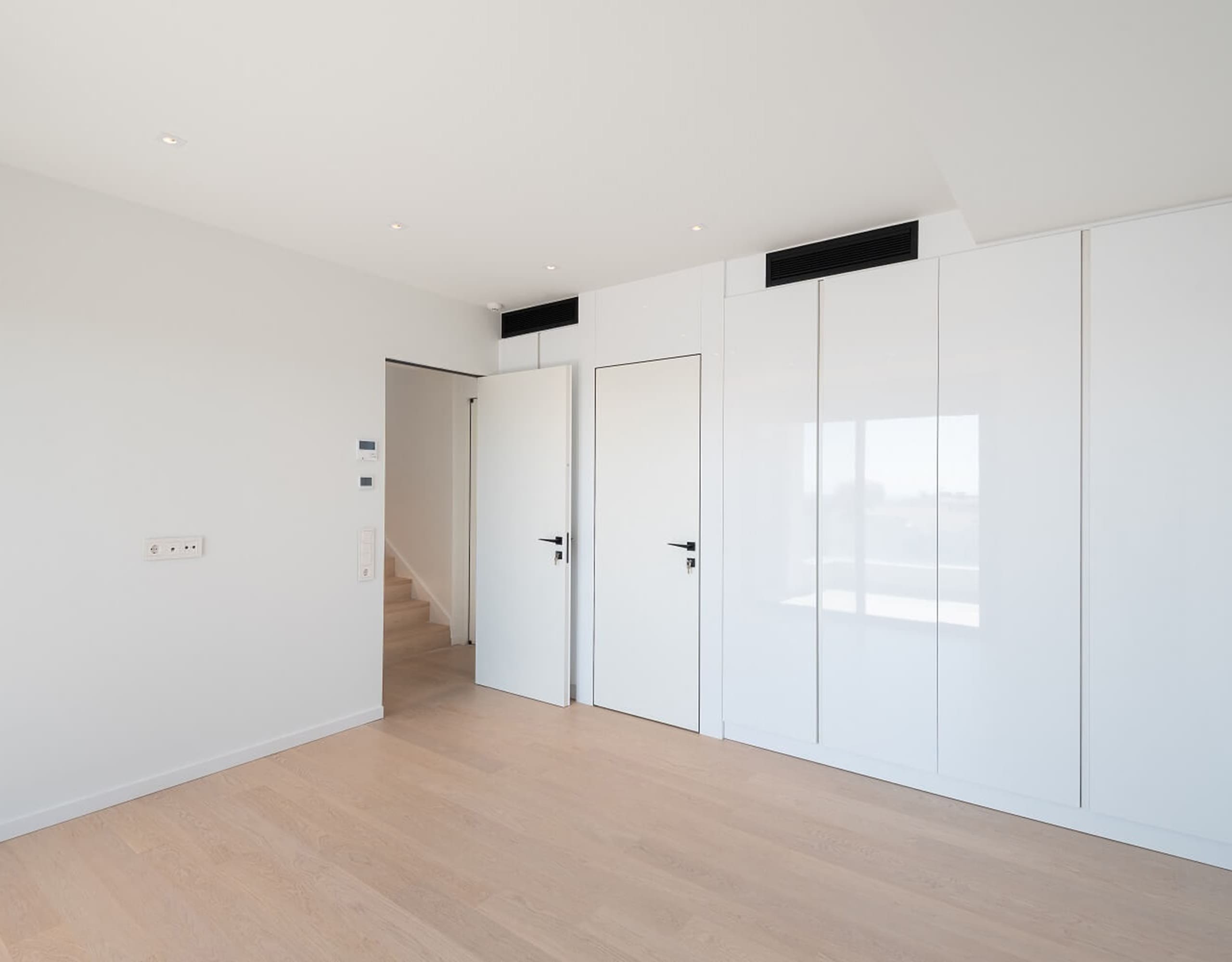 Minimal interior with glossy built-in wardrobes and clean white walls, Athens Riviera, Greece