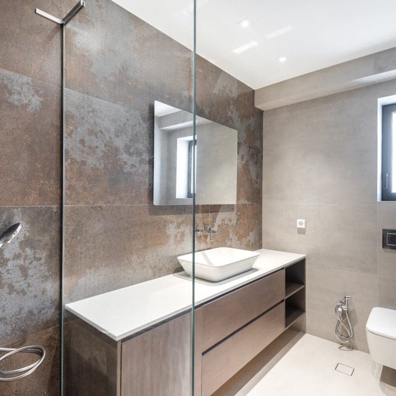 Modern bathroom with stone-textured walls, vanity, shower, and window, Athens Riviera, Greece