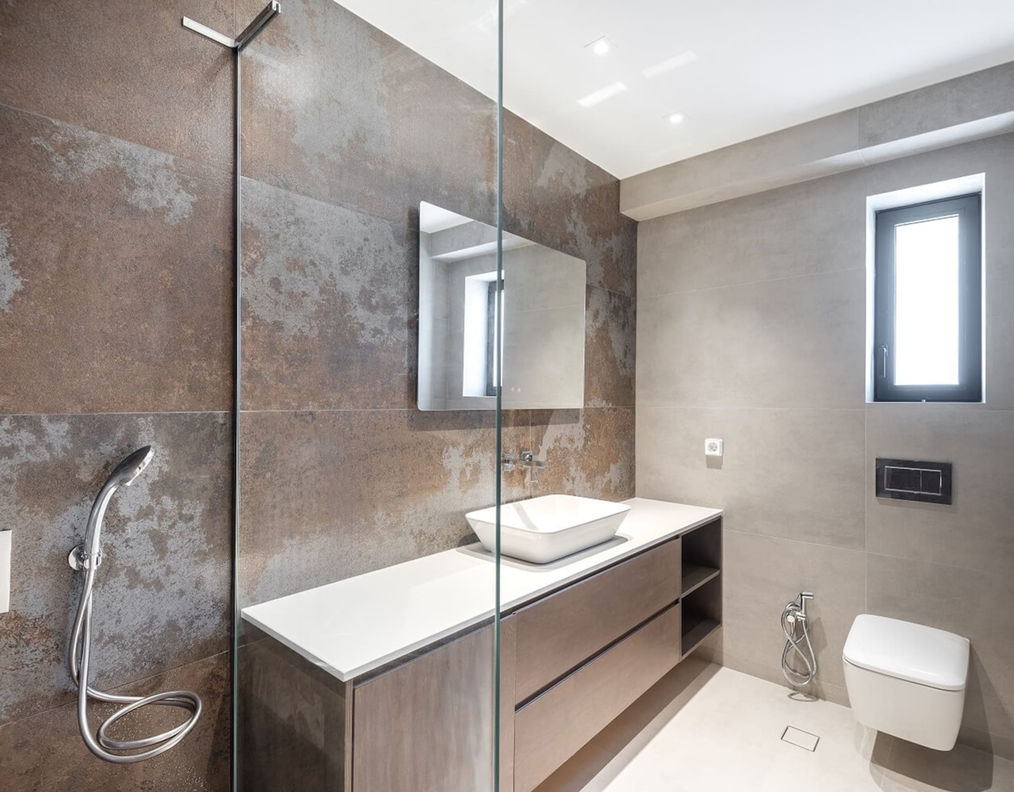 Modern bathroom with stone-textured walls, vanity, shower, and window, Athens Riviera, Greece