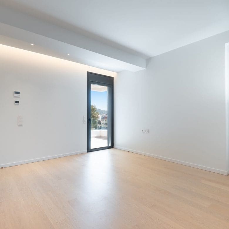 Minimal bright room with wood flooring and balcony door, Athens Riviera, Greece
