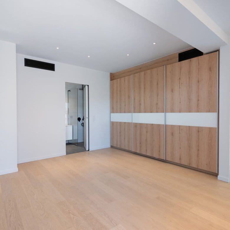 Modern room with built-in wood wardrobe wall and doorway to hall, Athens Riviera, Greece
