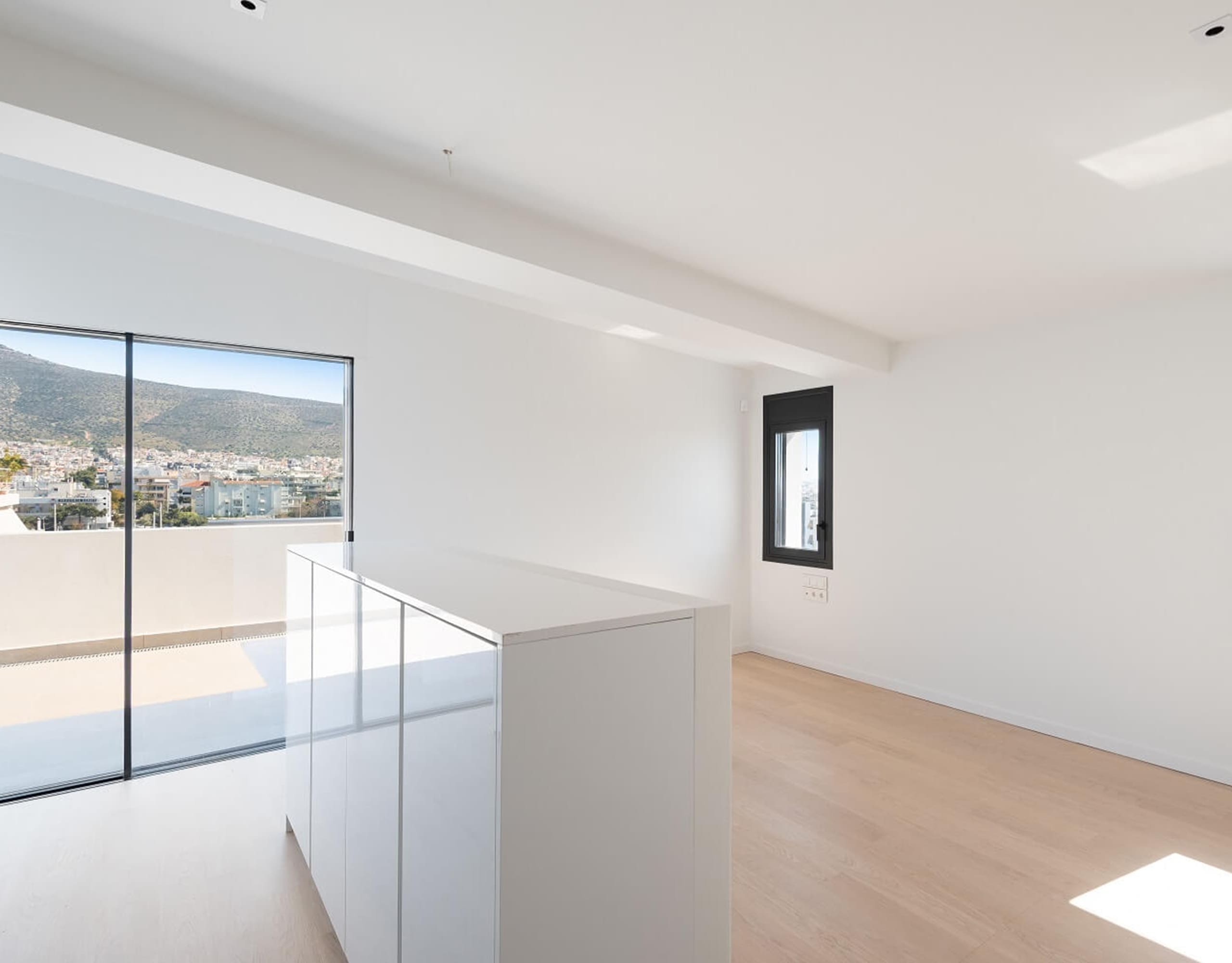 Bright upper-level landing with glass railing and large window, Athens Riviera, Greece