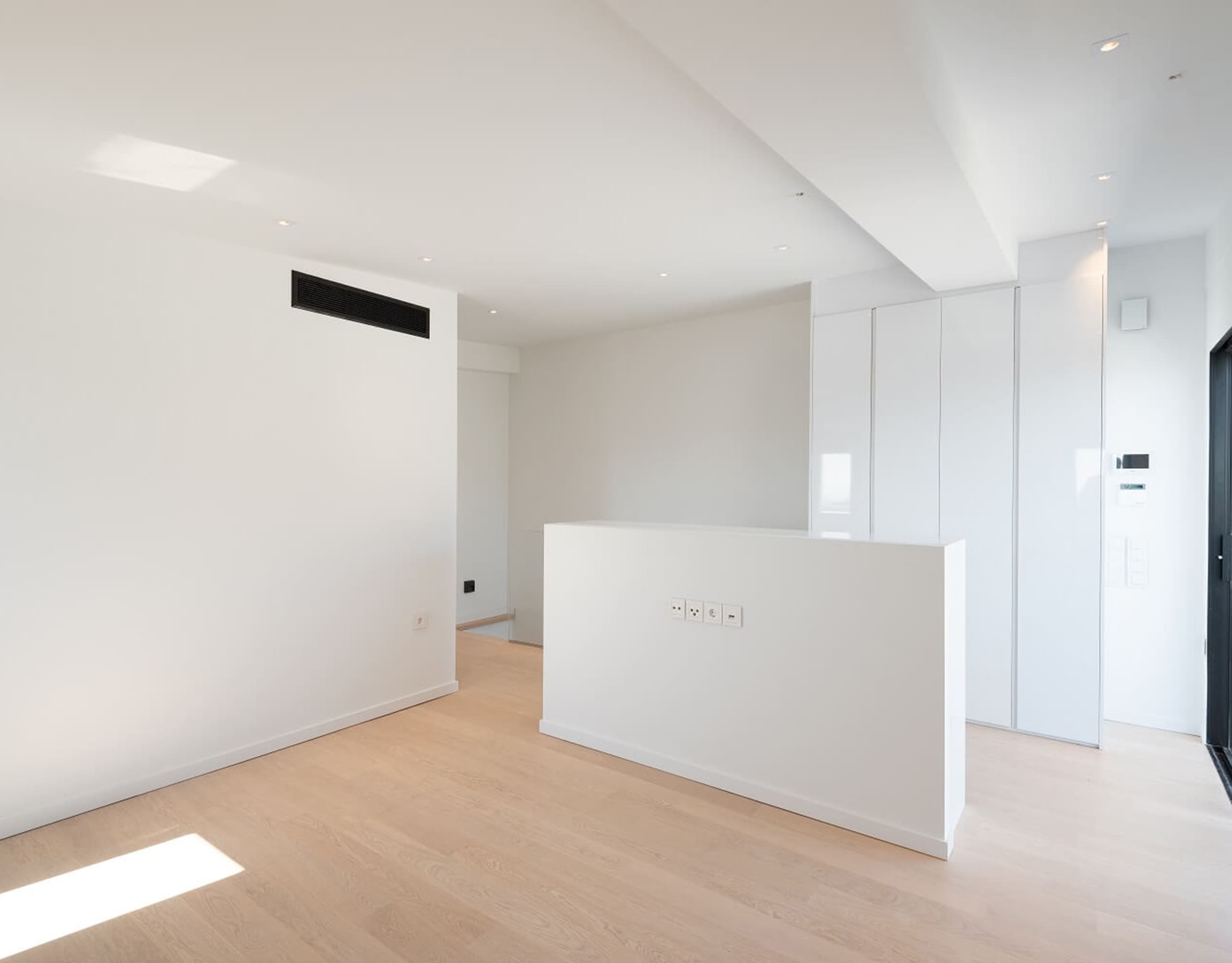 Bright open-plan living area with wood flooring and a central low partition, Athens Riviera, Greece