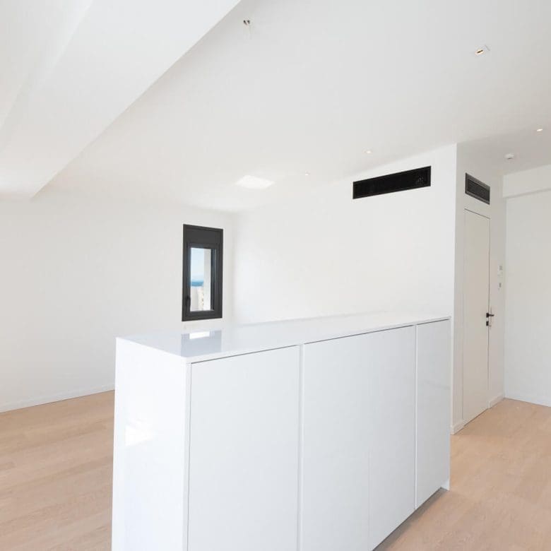 Modern kitchen area with white cabinetry, island, and recessed ceiling lighting, Athens Riviera, Greece