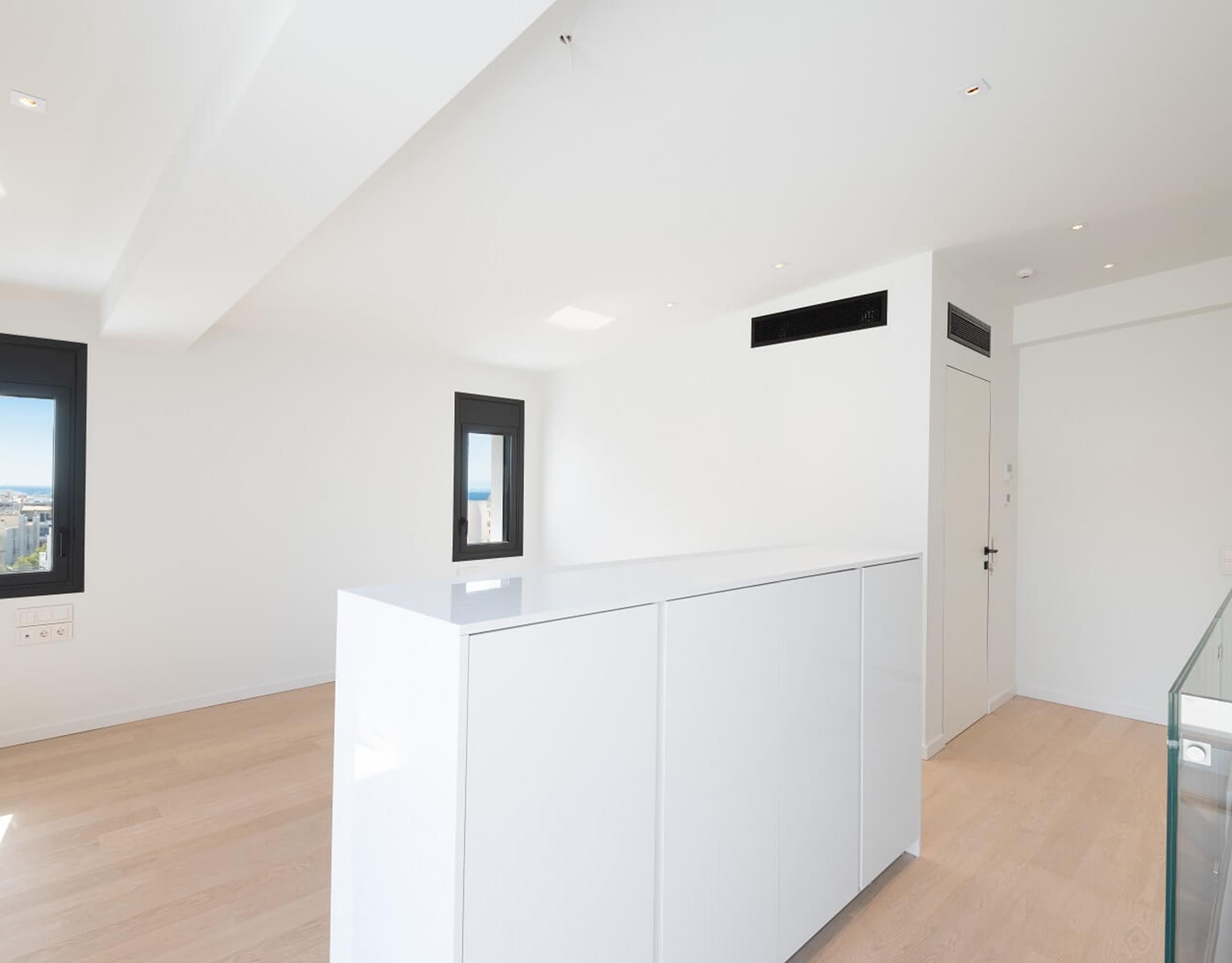 Modern kitchen area with white cabinetry, island, and recessed ceiling lighting, Athens Riviera, Greece