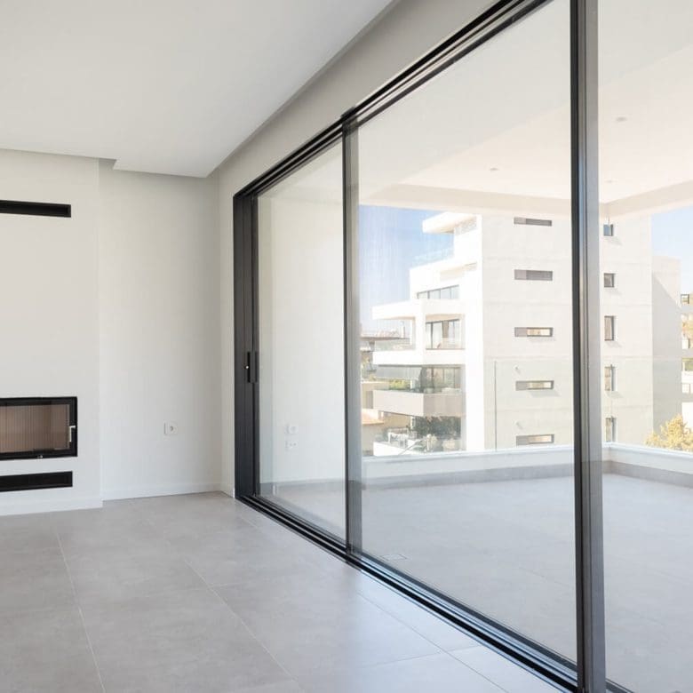 Floor-to-ceiling sliding glass doors opening to a balcony with neighborhood views, Athens Riviera, Greece