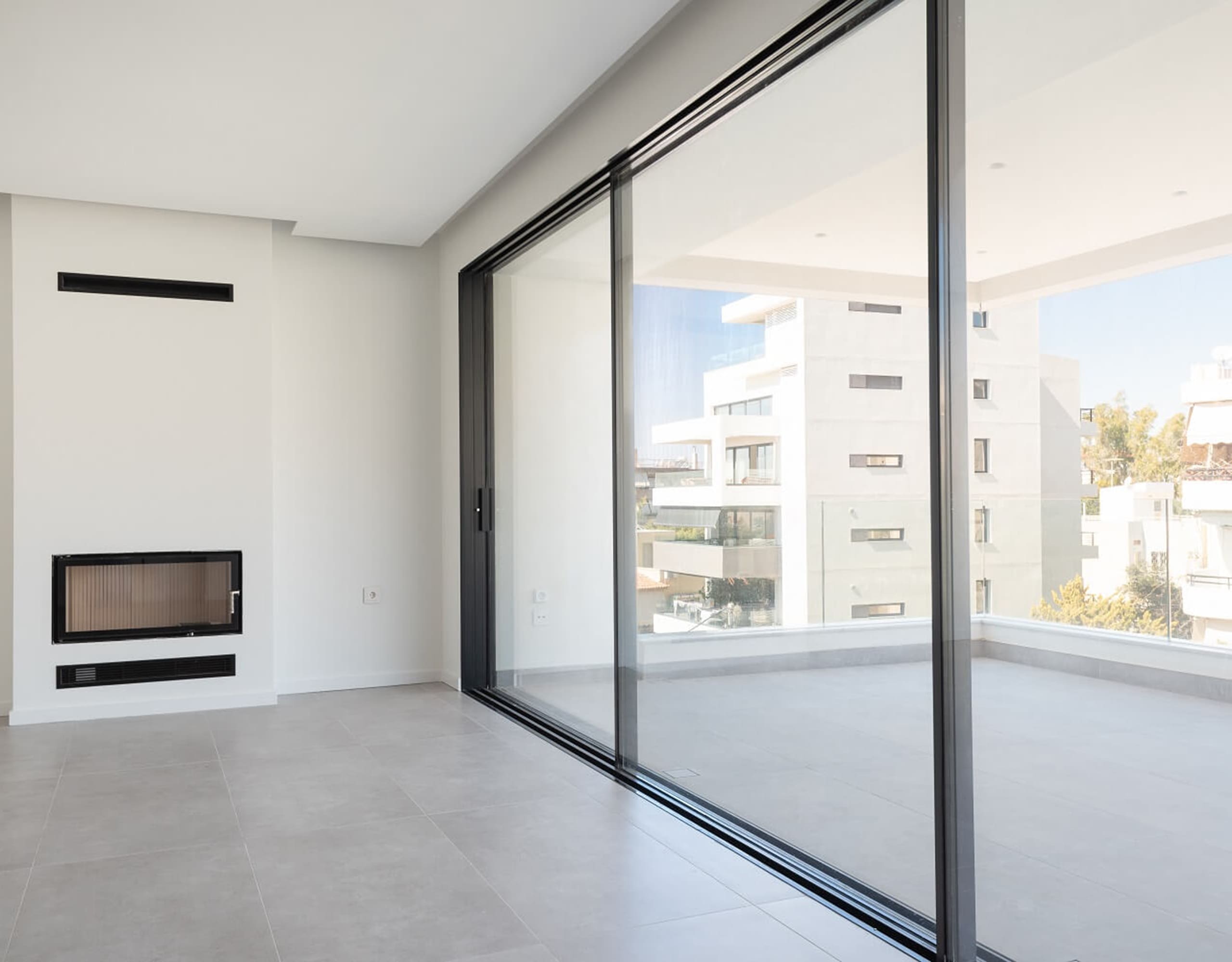 Floor-to-ceiling sliding glass doors opening to a balcony with neighborhood views, Athens Riviera, Greece