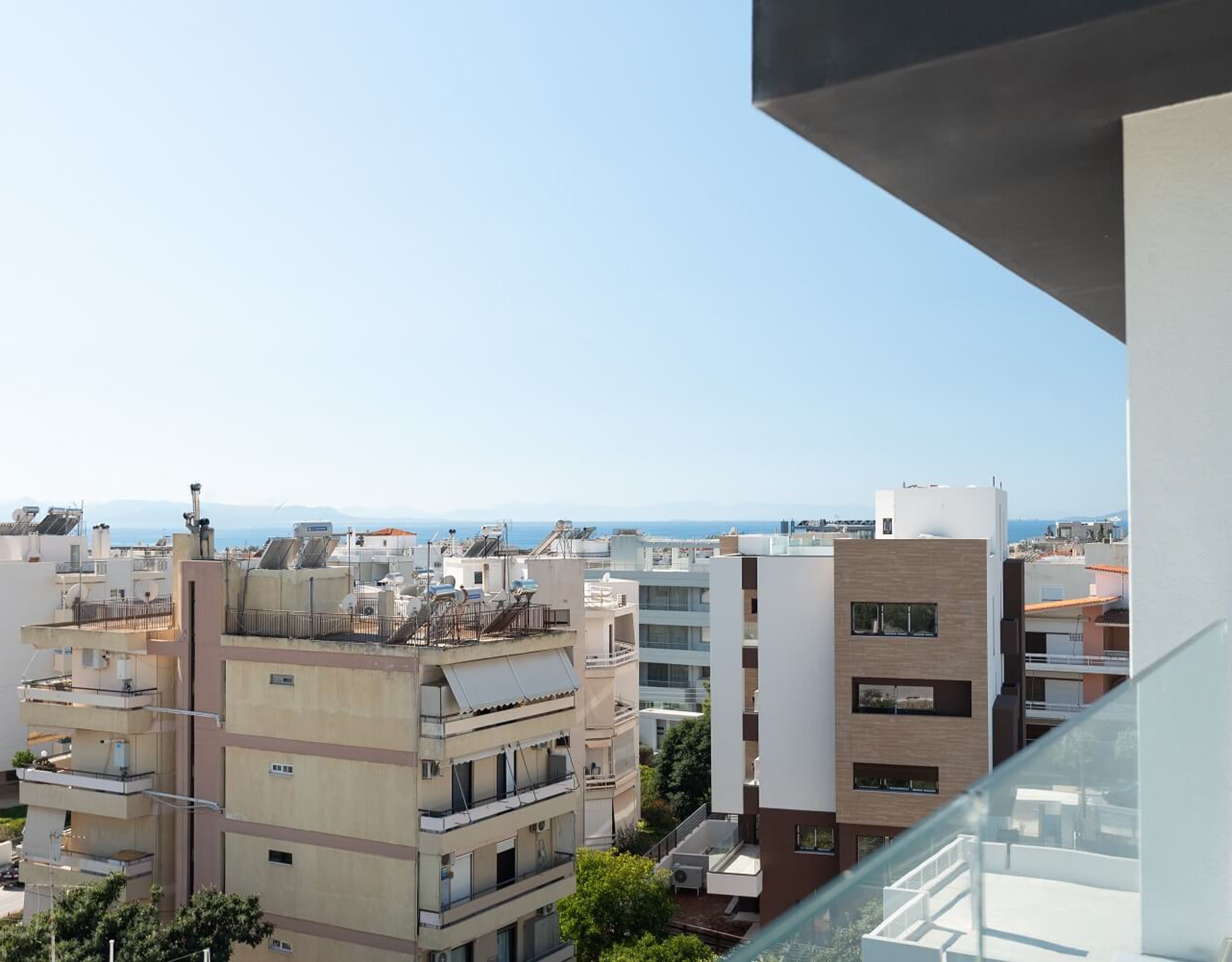Elevated balcony view over the neighborhood with distant sea horizon, Athens Riviera, Greece