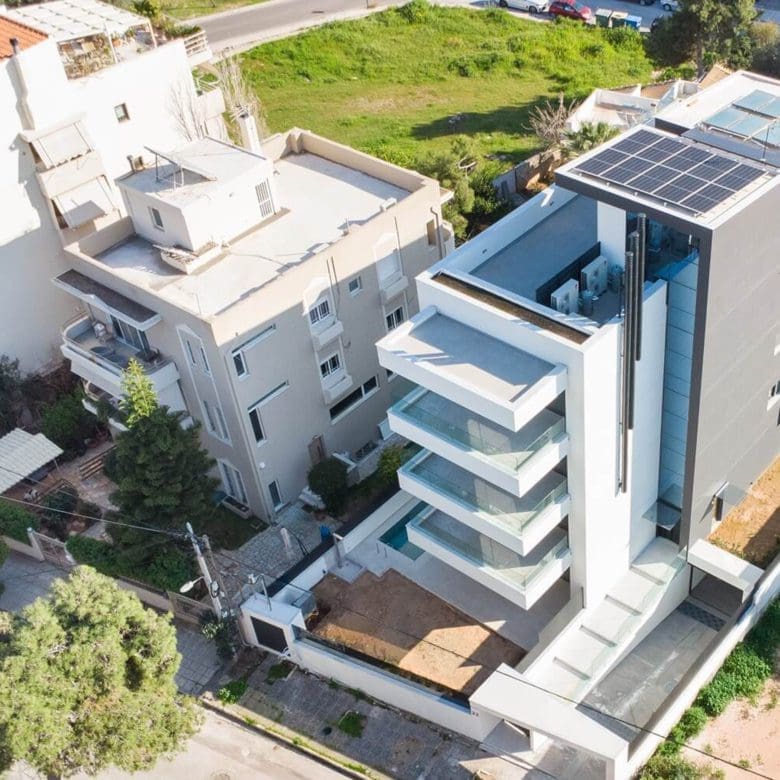 Aerial perspective of the modern villa facade with terraces and surrounding plots, Athens Riviera, Greece