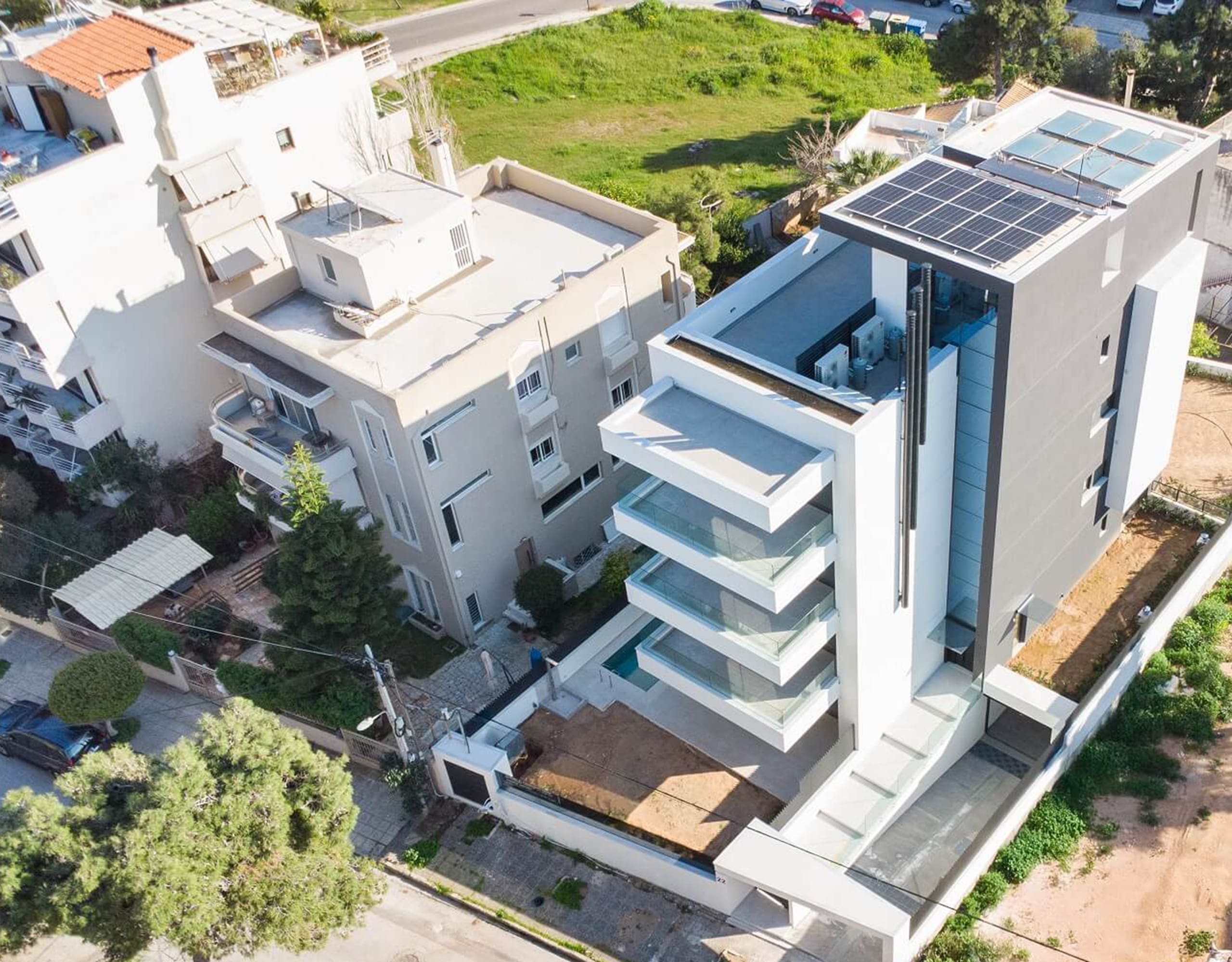 Aerial perspective of the modern villa facade with terraces and surrounding plots, Athens Riviera, Greece