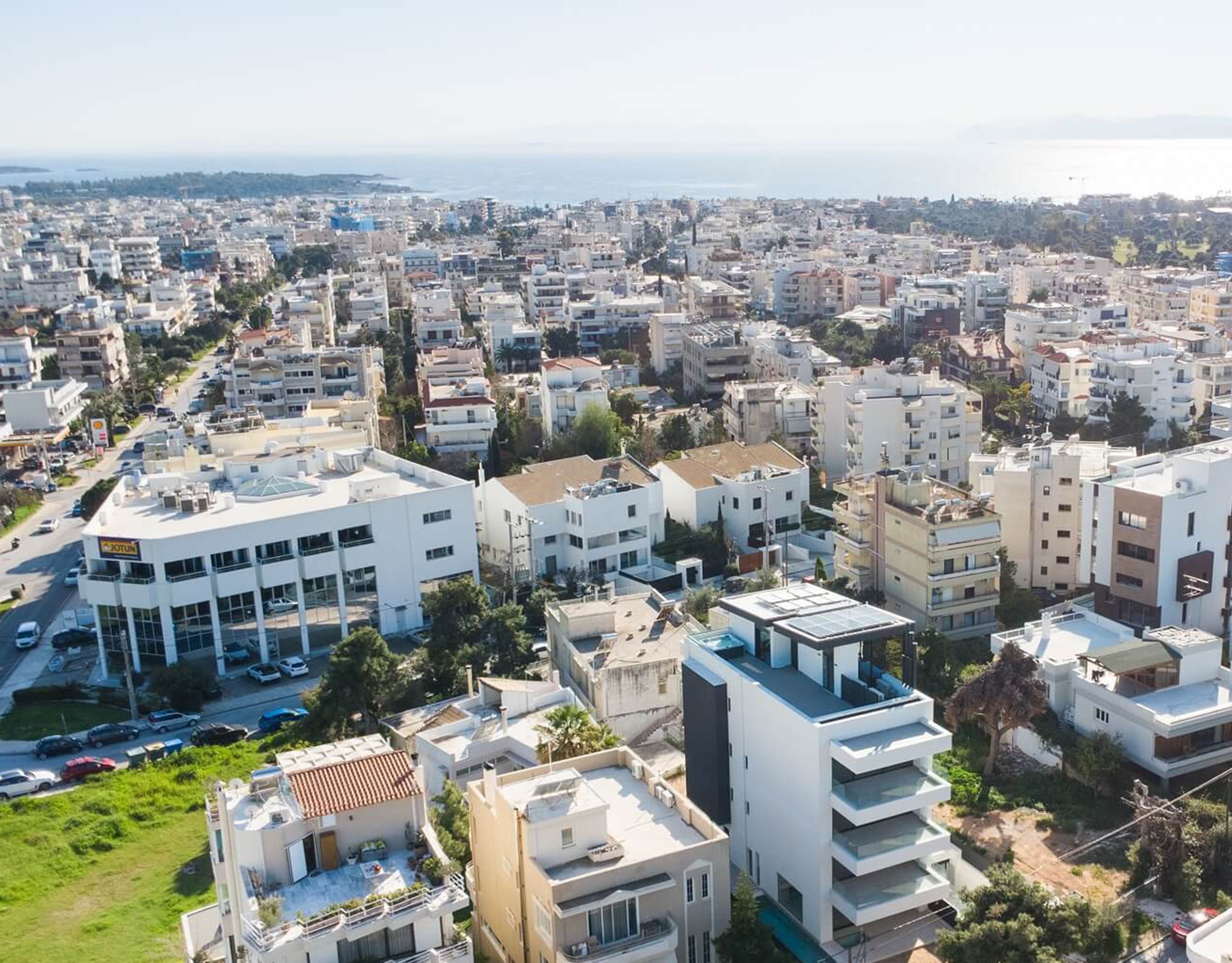 Wide drone view over the neighborhood with the modern villa in the foreground, Athens Riviera, Greece