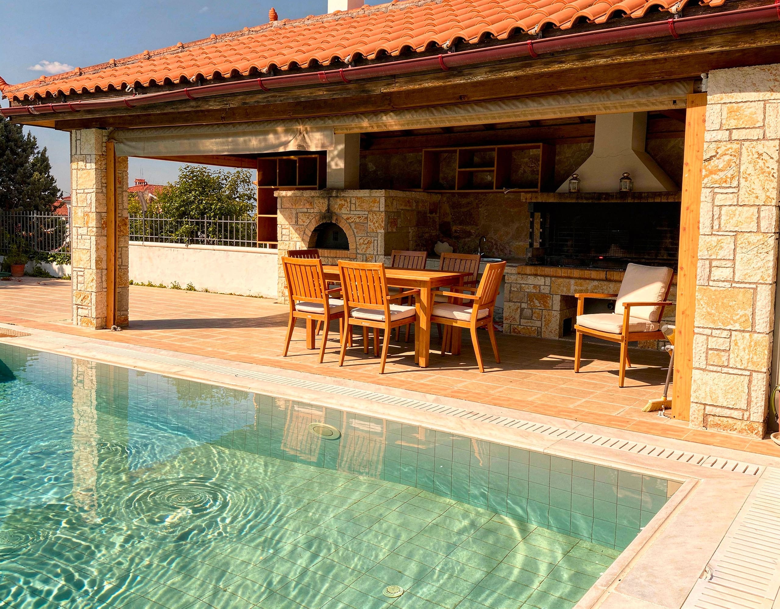 BBQ Area with Outdoor Kitchen — Eretria Property Covered BBQ area with outdoor kitchen and dining space in Eretria