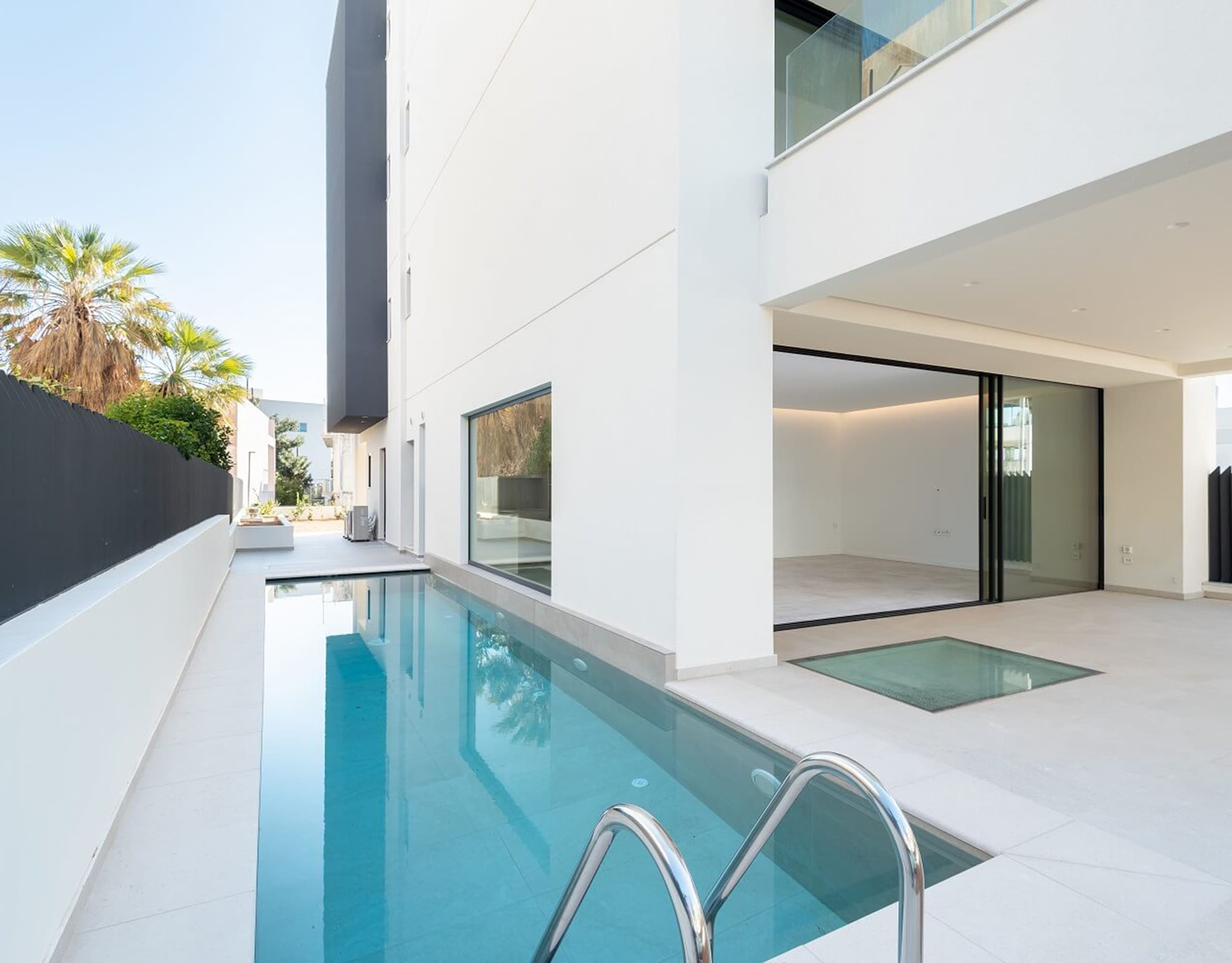 Narrow poolside corner with white modern villa facade and minimal deck, Athens Riviera, Greece