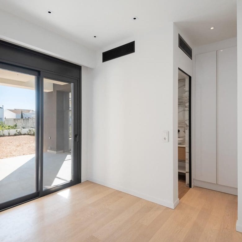 Modern ground-floor living area with large sliding doors opening to an outdoor patio, Athens Riviera, Greece