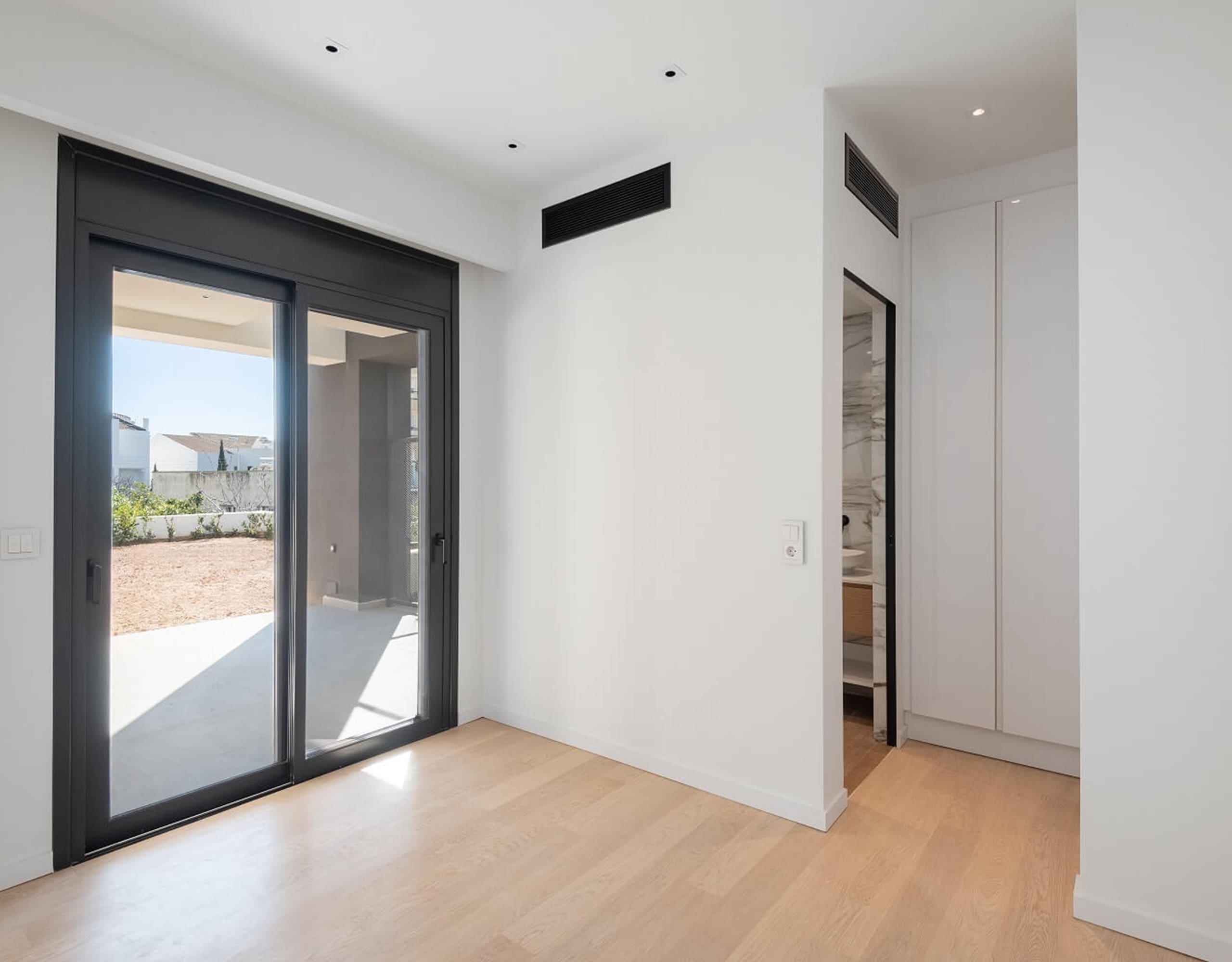 Modern ground-floor living area with large sliding doors opening to an outdoor patio, Athens Riviera, Greece