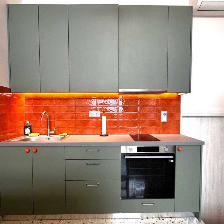Compact kitchen with green upper cabinets and orange backsplash, Pangrati, Athens, Greece