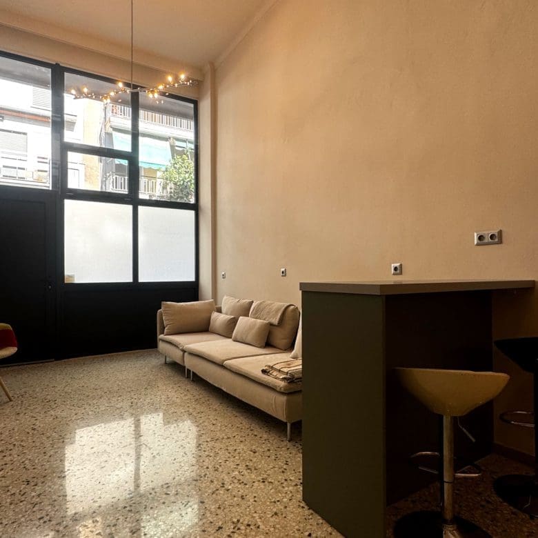 Open-plan living area with large window, bar counter seating, and compact layout, Pangrati, Athens, Greece