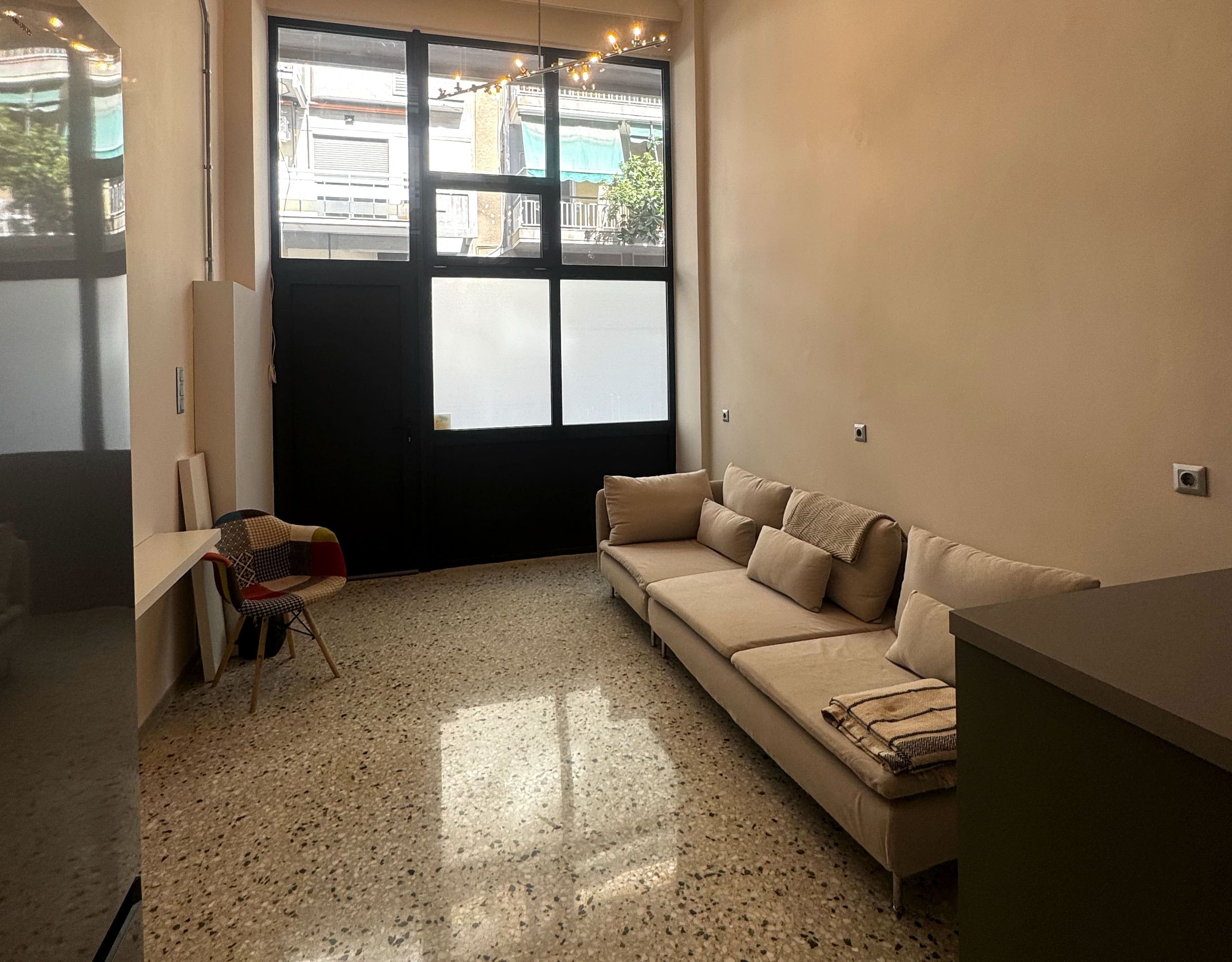 Pangrati Investment Apartment 51 sqm – Living Room With Large Window Living room with sofa and large window bringing in natural light, Pangrati, Athens, Greece