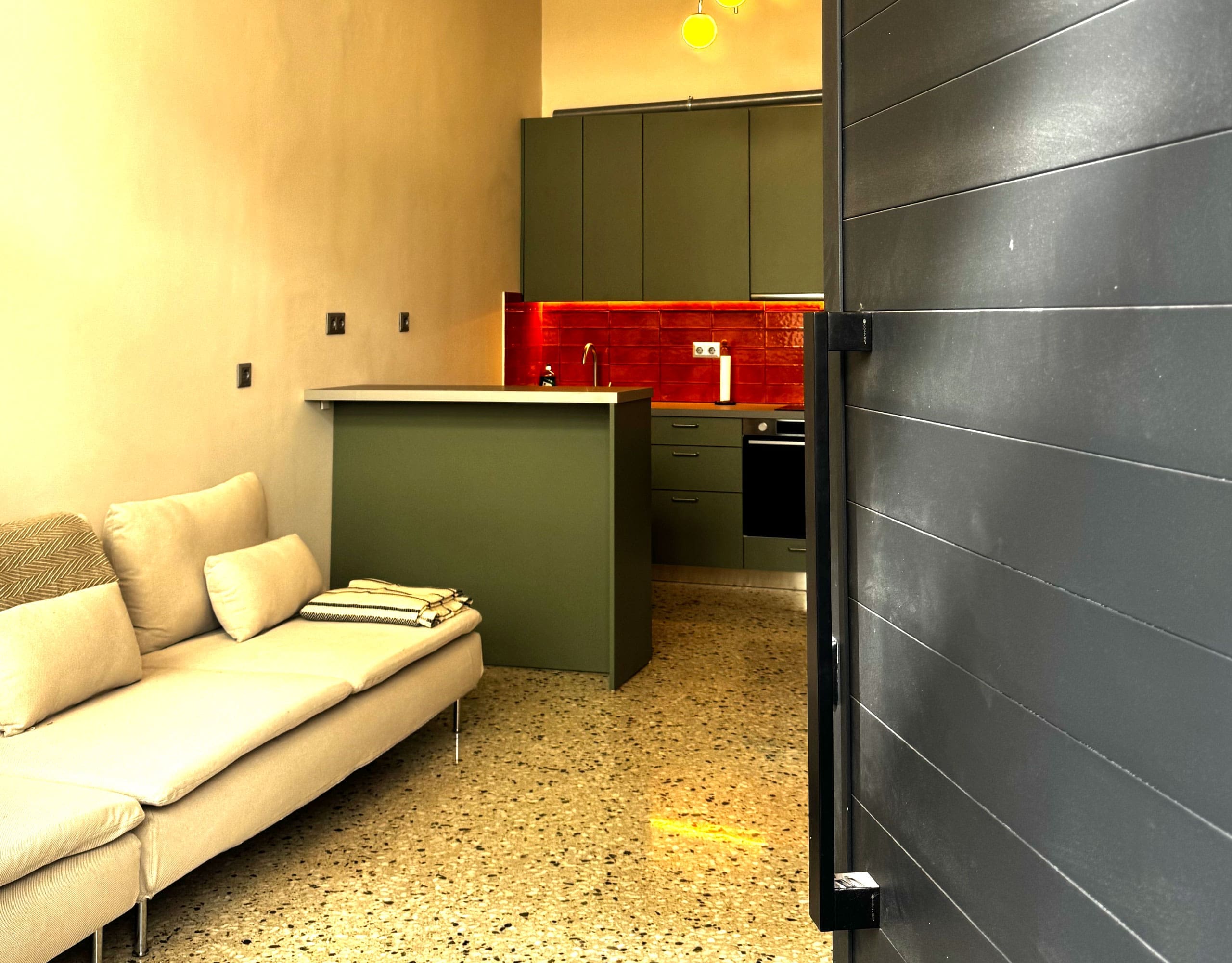 Pangrati Investment Apartment 51 sqm – Open-Plan Living And Kitchen Open-plan living area with sofa and modern kitchen with green cabinetry, Pangrati, Athens, Greece