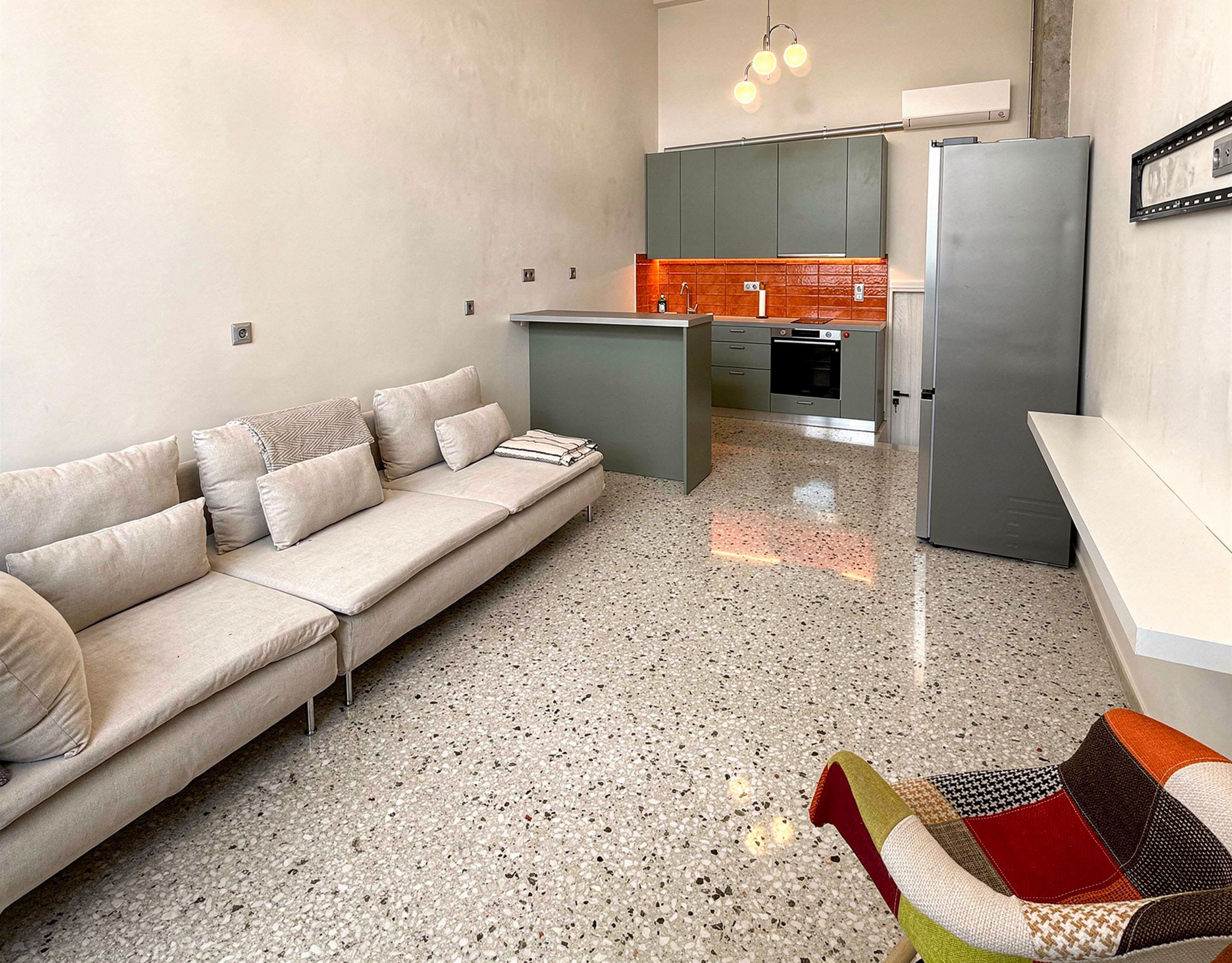 Pangrati Investment Apartment 51 sqm – Living Room And Kitchen View Open-plan living room with sofa and kitchen area in the background, Pangrati, Athens, Greece