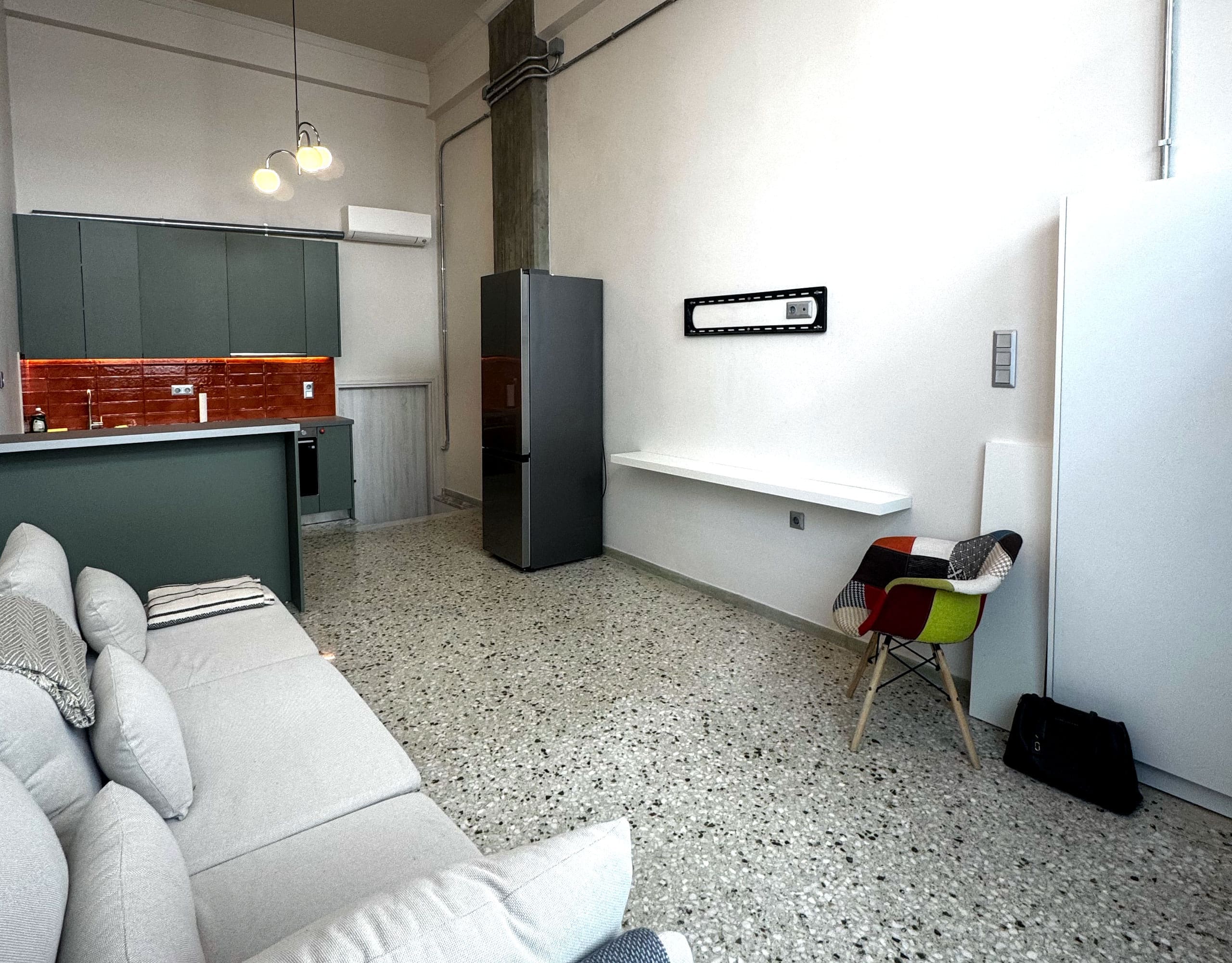 Pangrati Investment Apartment 51 sqm – Open-Plan Living Area Open-plan studio living area with sofa, bed, and compact layout, Pangrati, Athens, Greece