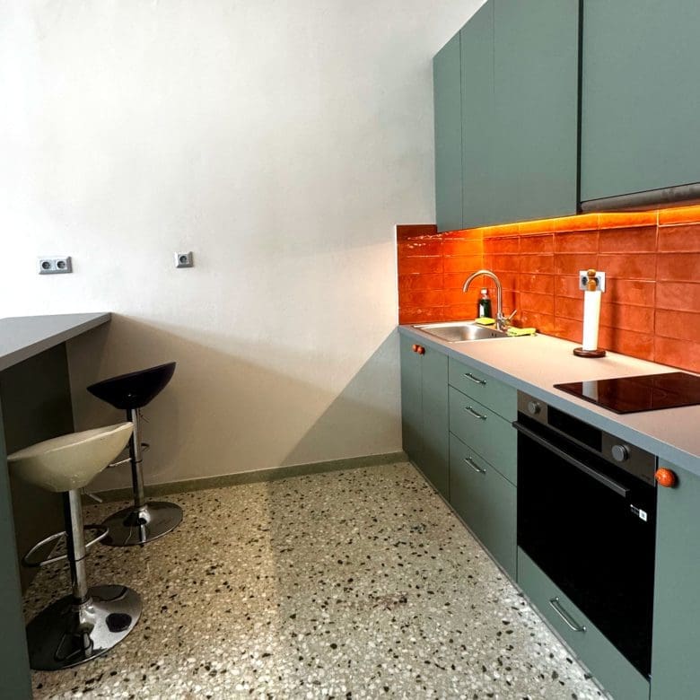 Kitchen detail with green cabinets, bar stool, and orange tile backsplash, Pangrati, Athens, Greece