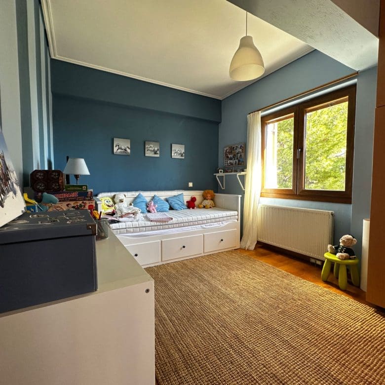 Children’s bedroom with blue walls, single beds, and wood flooring, Thrakomakedones, Athens, Greece