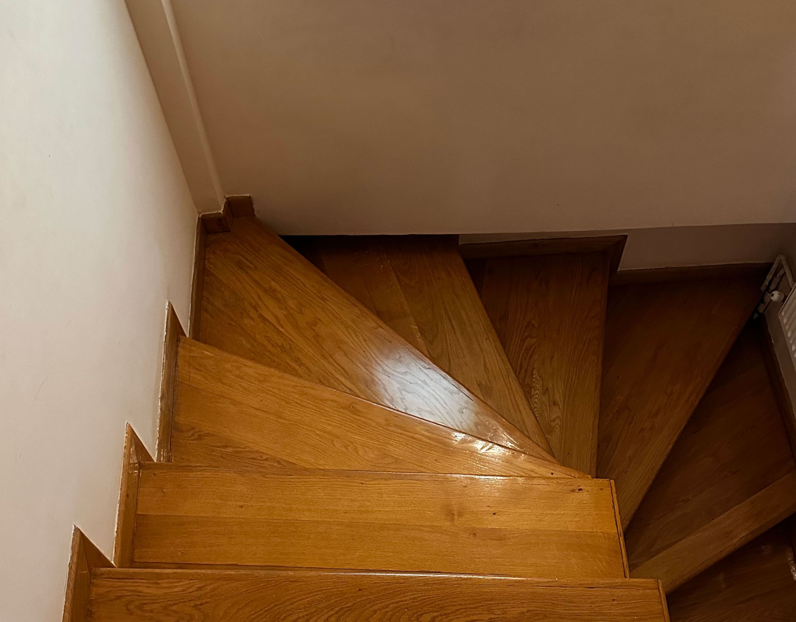 Wooden staircase detail with turning steps and white walls, Thrakomakedones, Athens, Greece