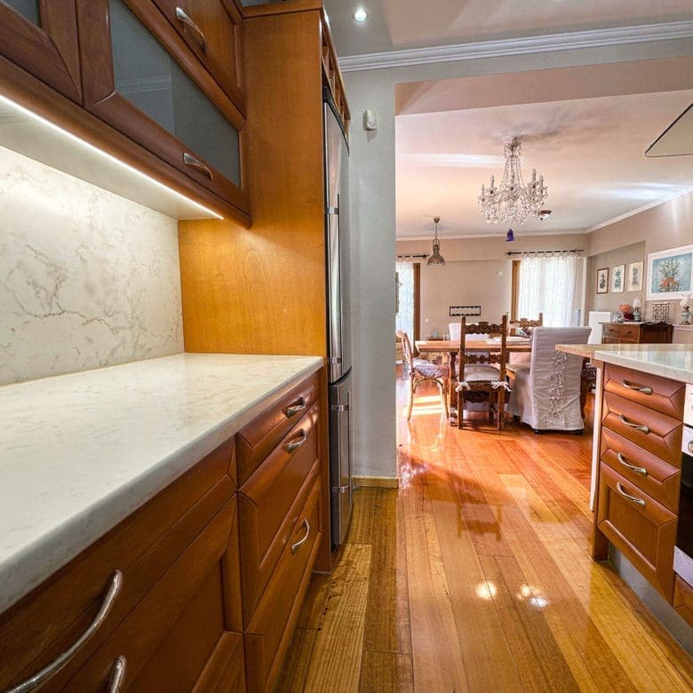 Kitchen with wooden cabinetry, long countertop, and pass-through opening, Thrakomakedones, Athens, Greece