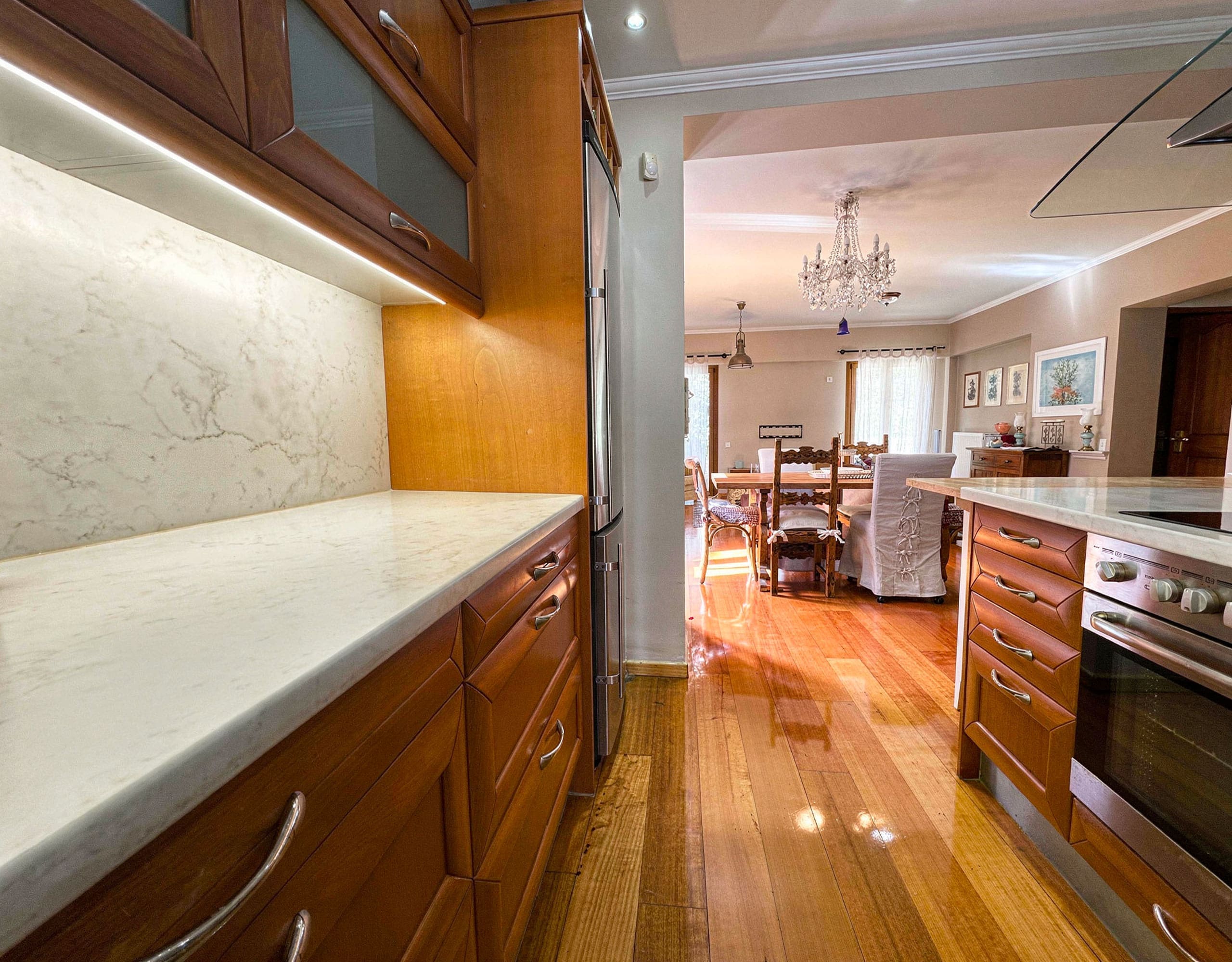 Kitchen with wooden cabinetry, long countertop, and pass-through opening, Thrakomakedones, Athens, Greece