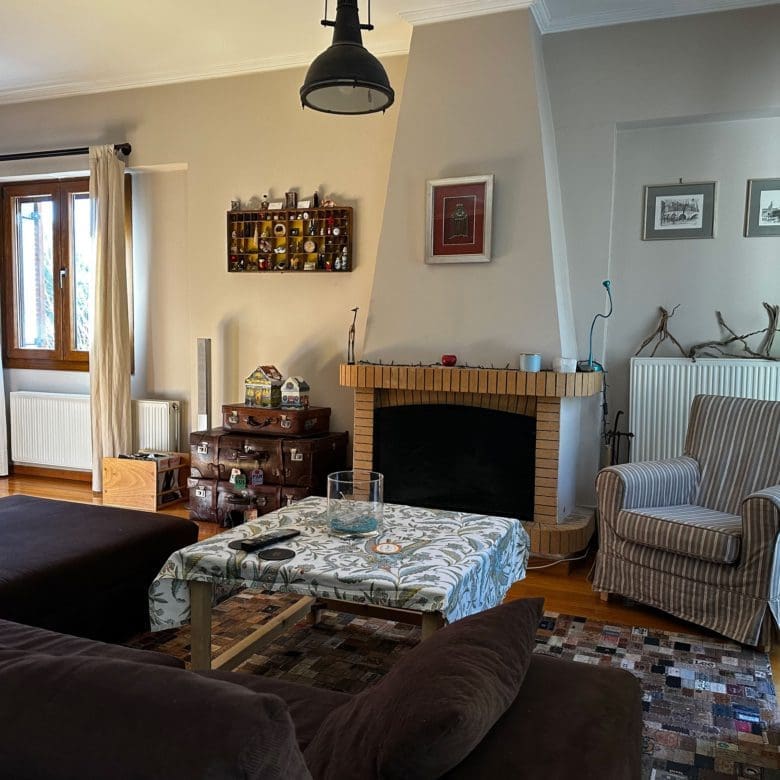 Living room with fireplace, seating area, and pendant light, Thrakomakedones, Athens, Greece