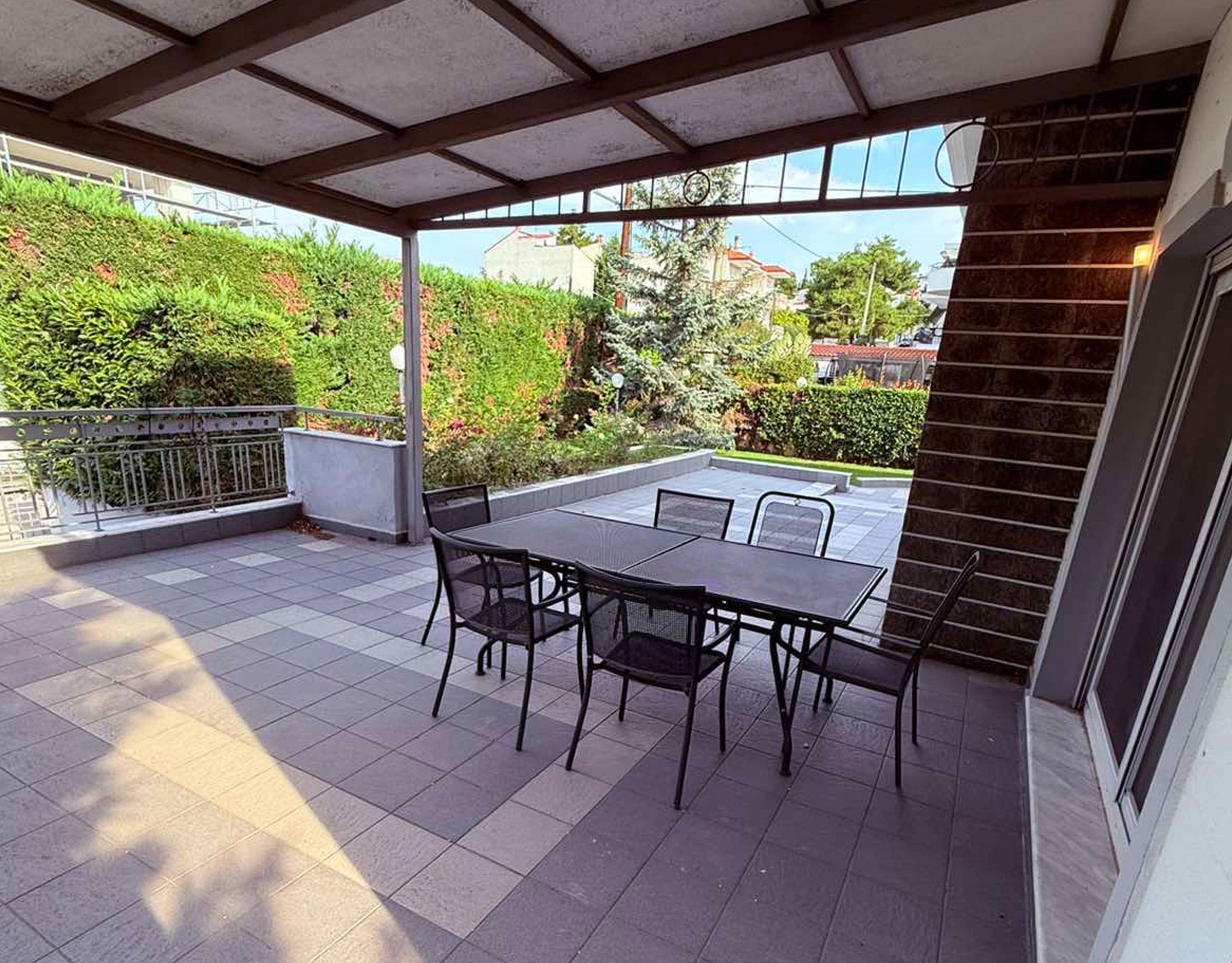 Covered balcony with outdoor dining table and garden views, Oreokastro, Thessaloniki, Greece
