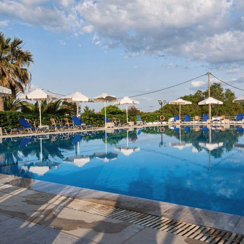 Swimming pool with sun loungers and umbrellas under a bright sky, Skala Kallonis, Lesvos, Greece