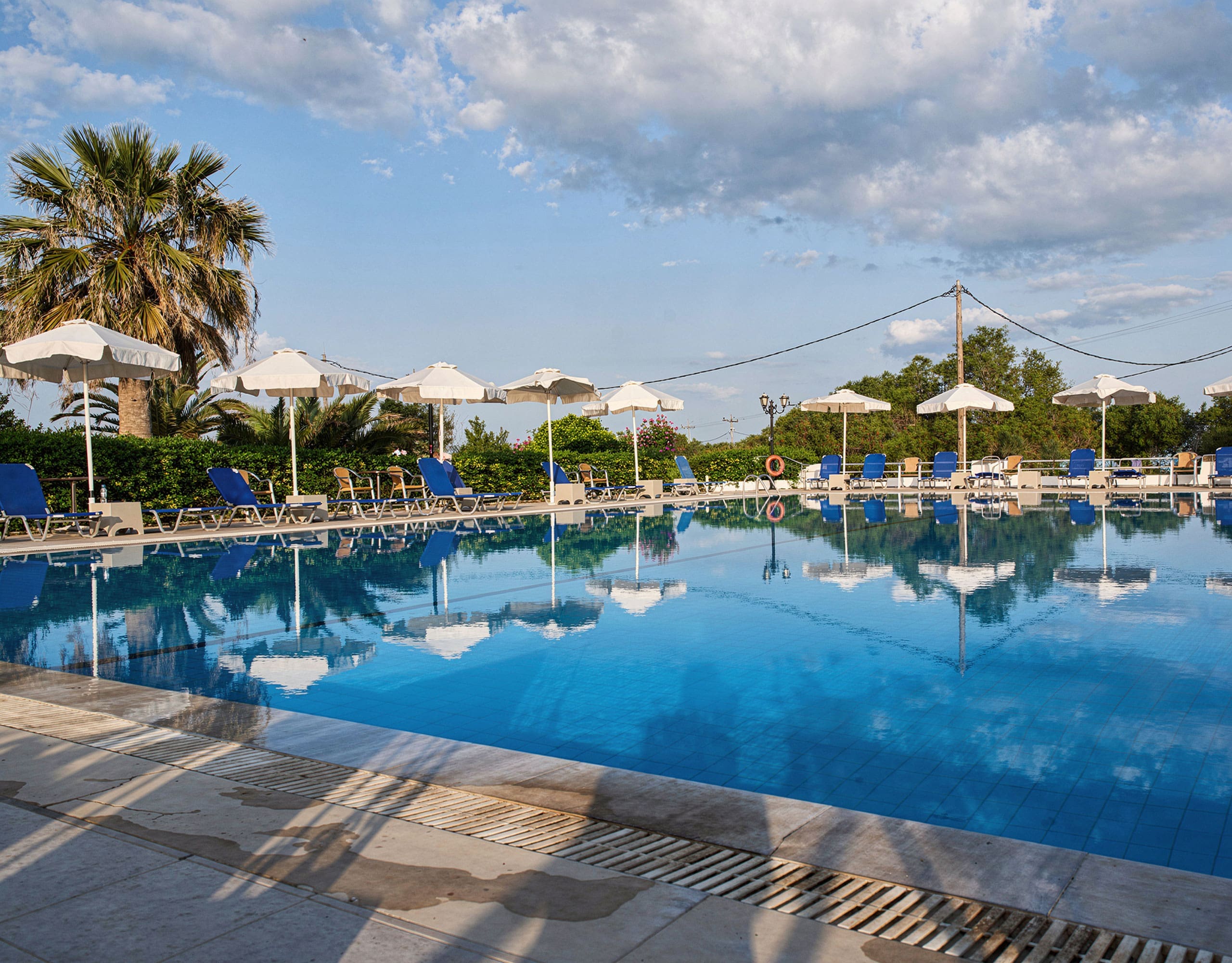Skala Kallonis 3-Star Beachfront Hotel – Pool With Sun Loungers Swimming pool with sun loungers and umbrellas under a bright sky, Skala Kallonis, Lesvos, Greece