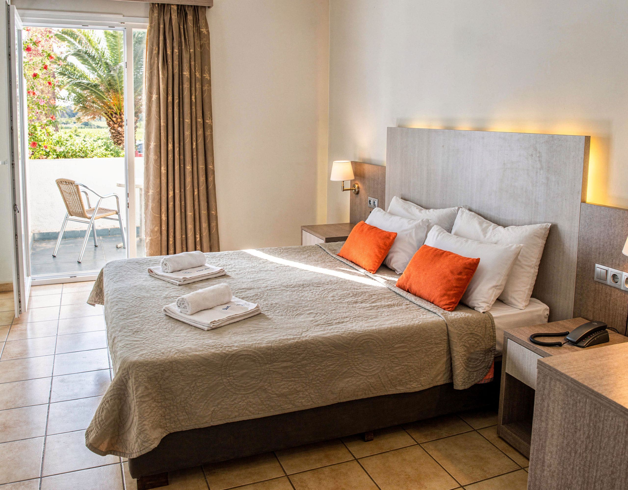 Skala Kallonis 3-Star Beachfront Hotel – Guest Bedroom With Balcony Access Guest bedroom with double bed, orange accent pillows, and balcony access, Skala Kallonis, Lesvos, Greece