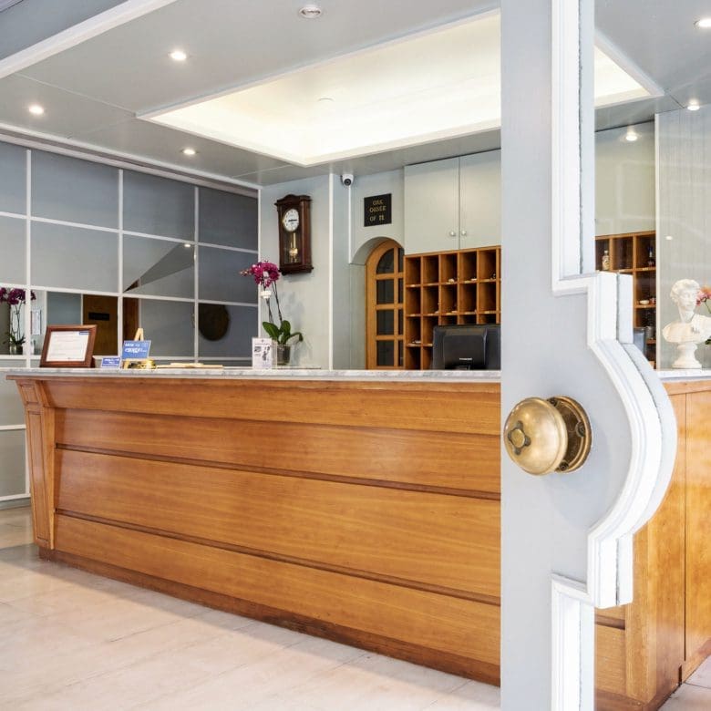 Hotel reception area with wooden front desk and bright interior lighting, Skala Kallonis, Lesvos, Greece