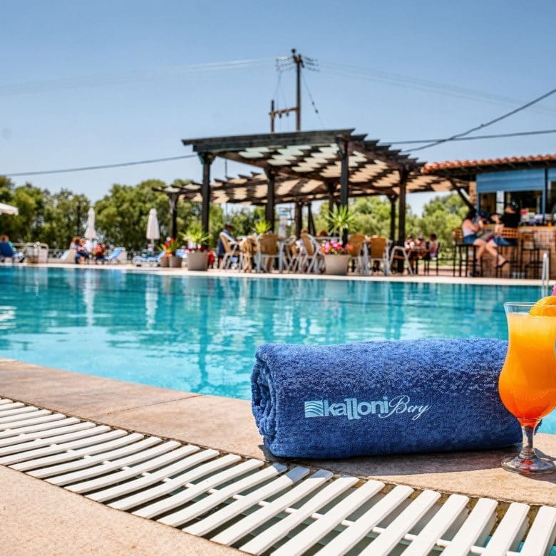 Poolside view with swimming pool, bar area, and a cold drink on the deck, Skala Kallonis, Lesvos, Greece
