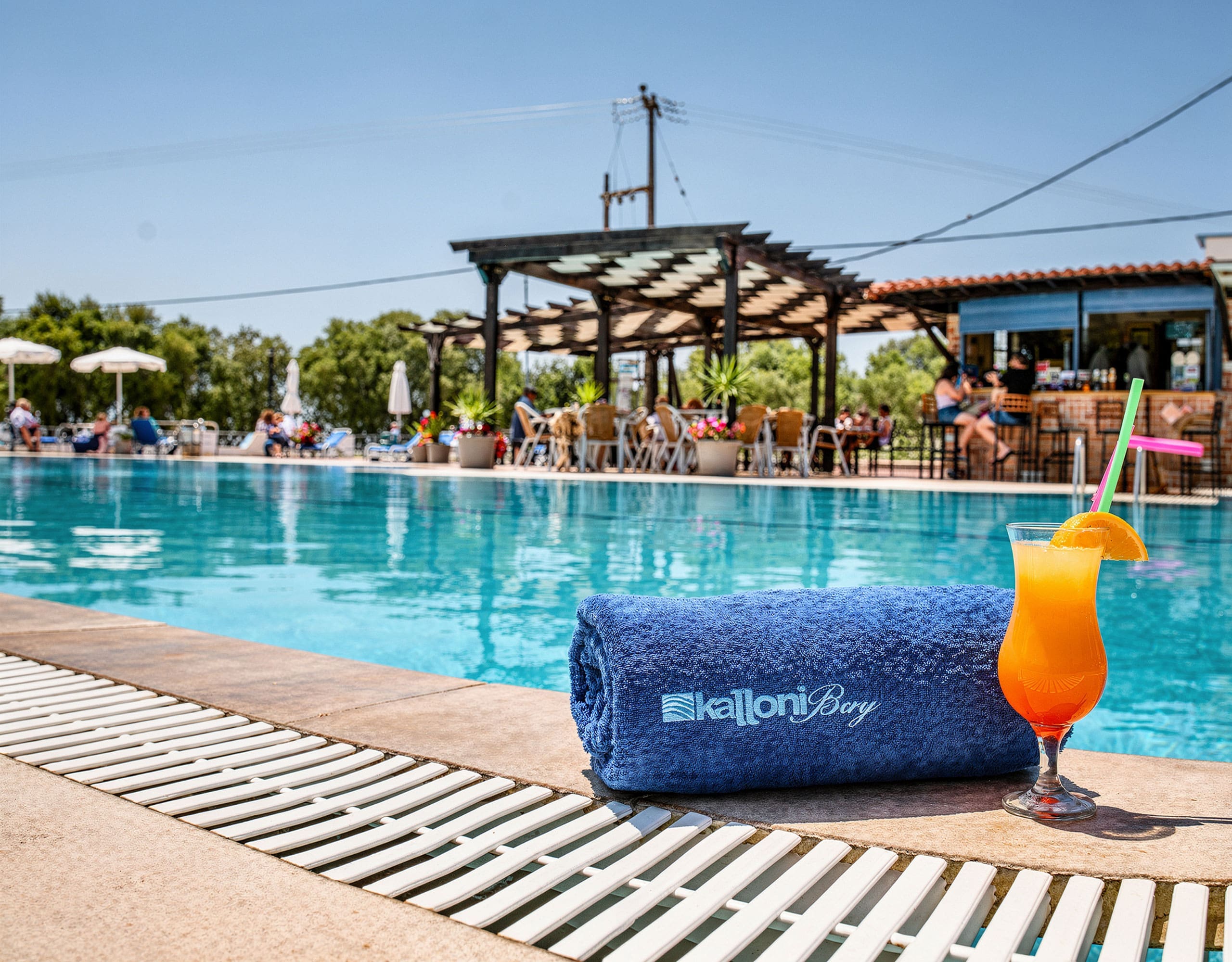 Skala Kallonis 3-Star Beachfront Hotel – Poolside Bar And Drink Poolside view with swimming pool, bar area, and a cold drink on the deck, Skala Kallonis, Lesvos, Greece