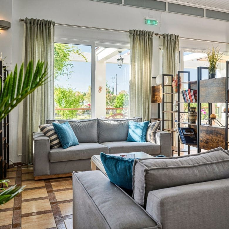 Hotel lounge area with sofa seating, indoor plants, and natural light, Skala Kallonis, Lesvos, Greece